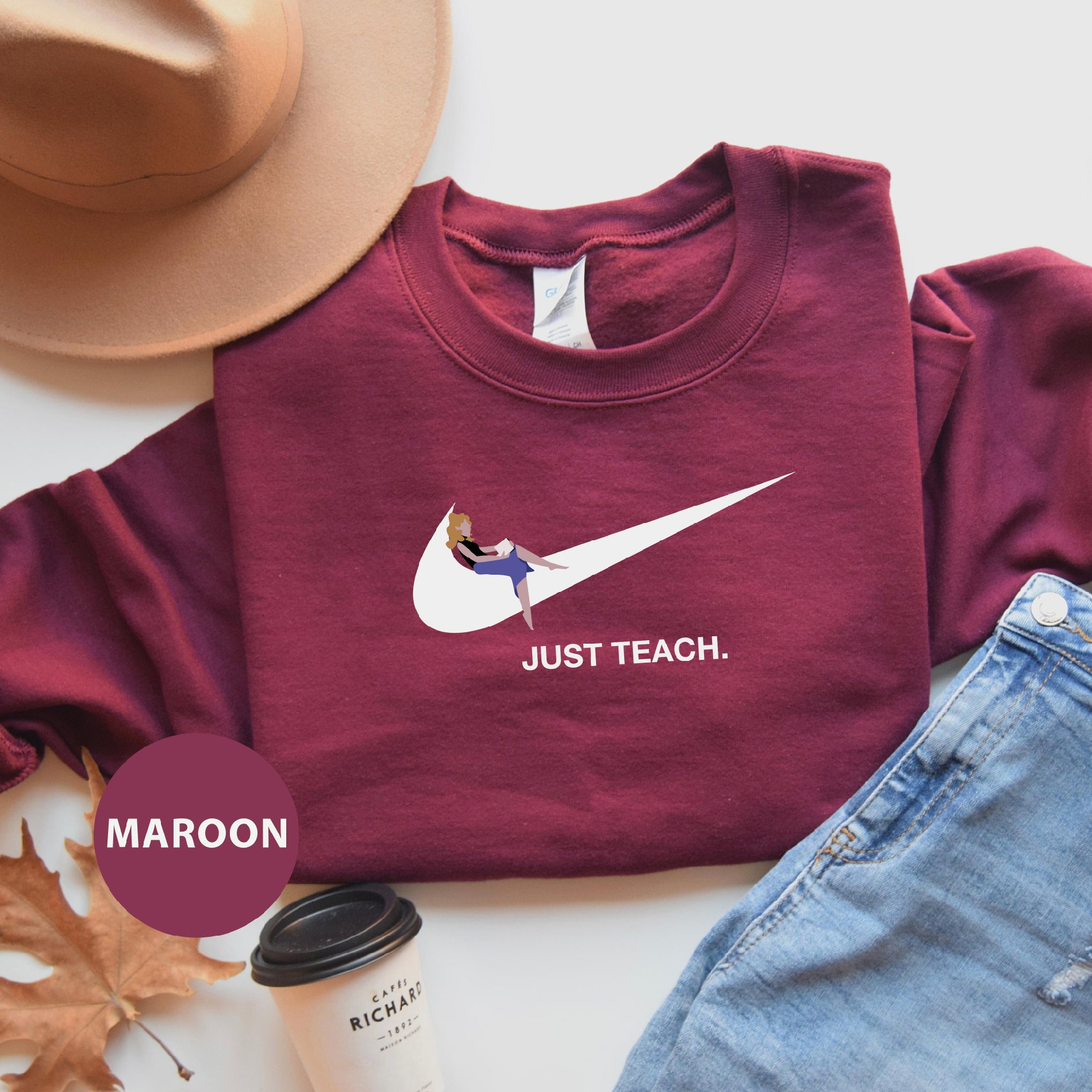a maroon shirt that says just teach with a bird on it