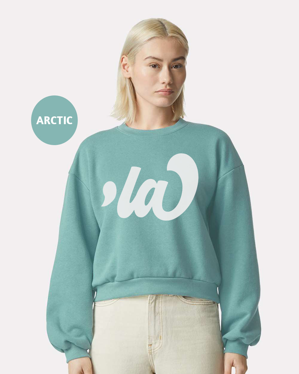 a woman with blonde hair wearing a blue sweatshirt with white letters on it