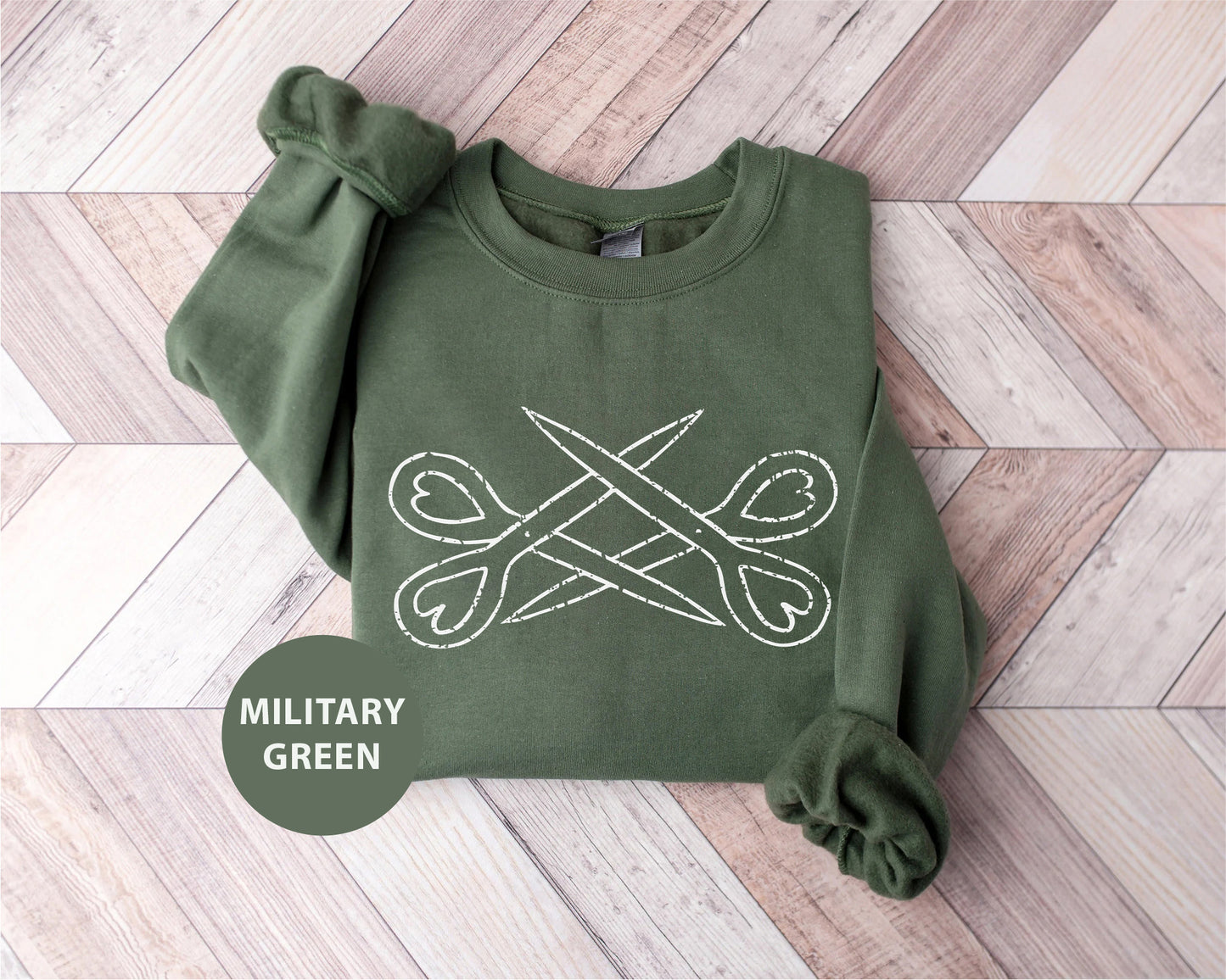 a military green sweatshirt with scissors on it