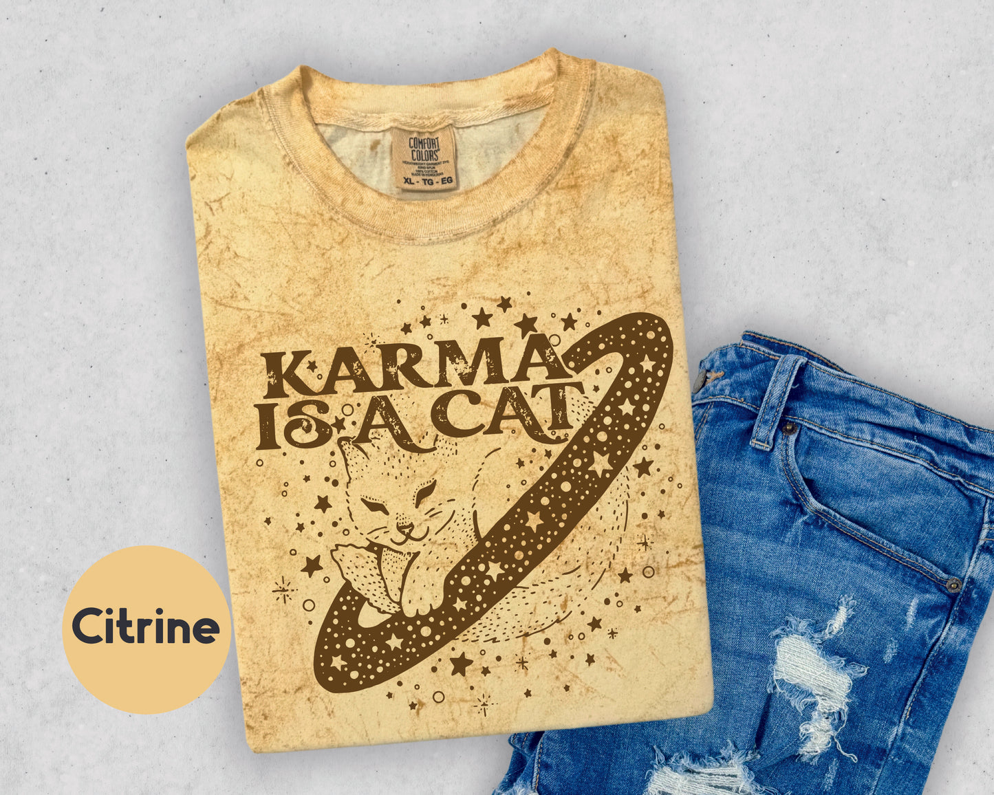 a t - shirt that says karma is a cat next to a pair of ripped