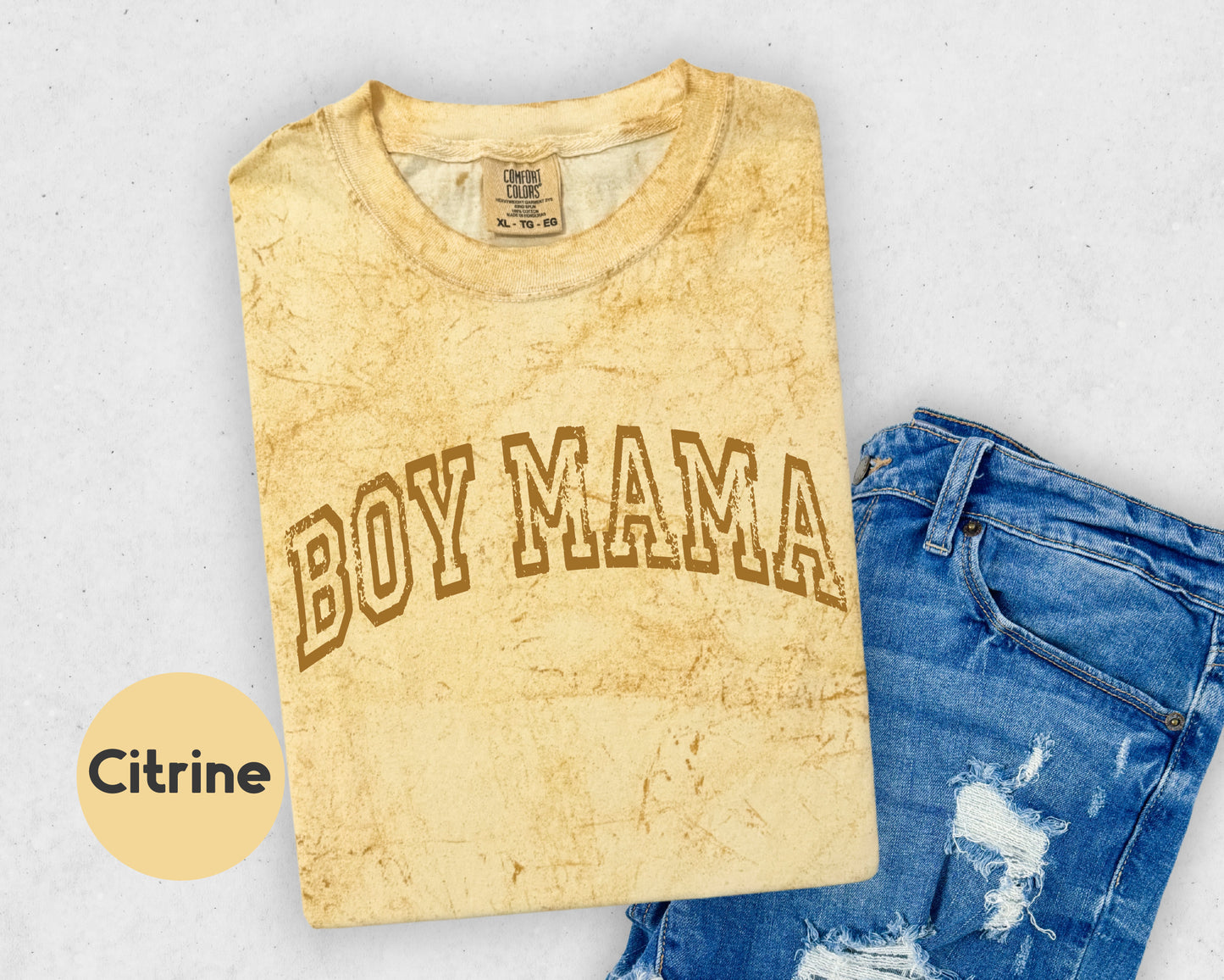 a shirt that says boy mama next to a pair of ripped jeans