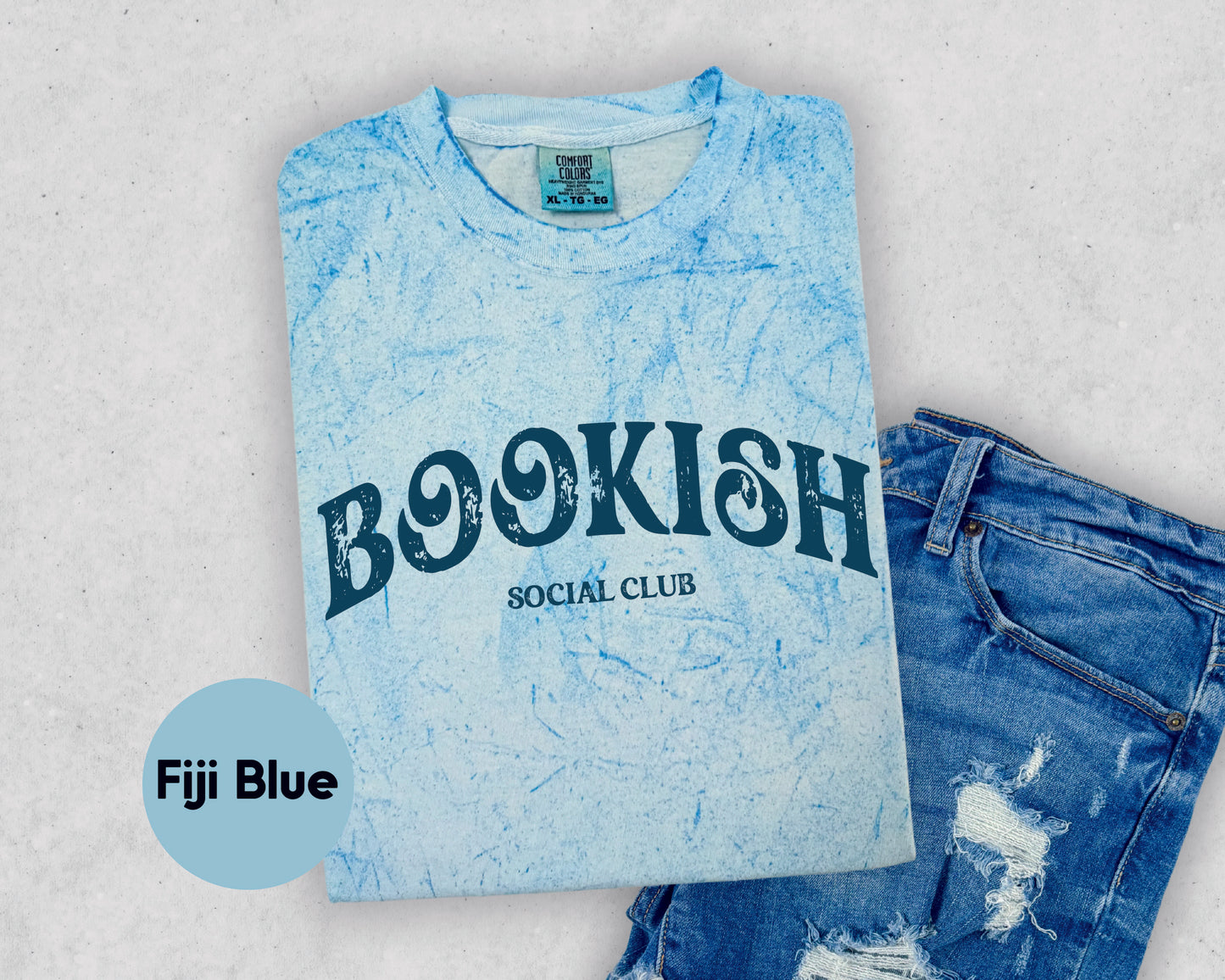 a t - shirt that says bookish social club next to a pair of ripped