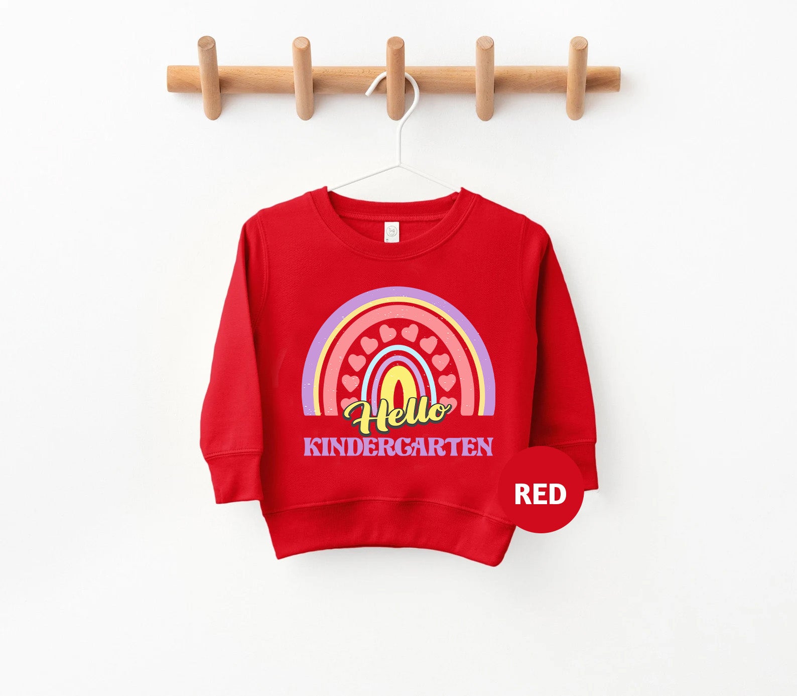 a red sweatshirt hanging on a wooden hanger