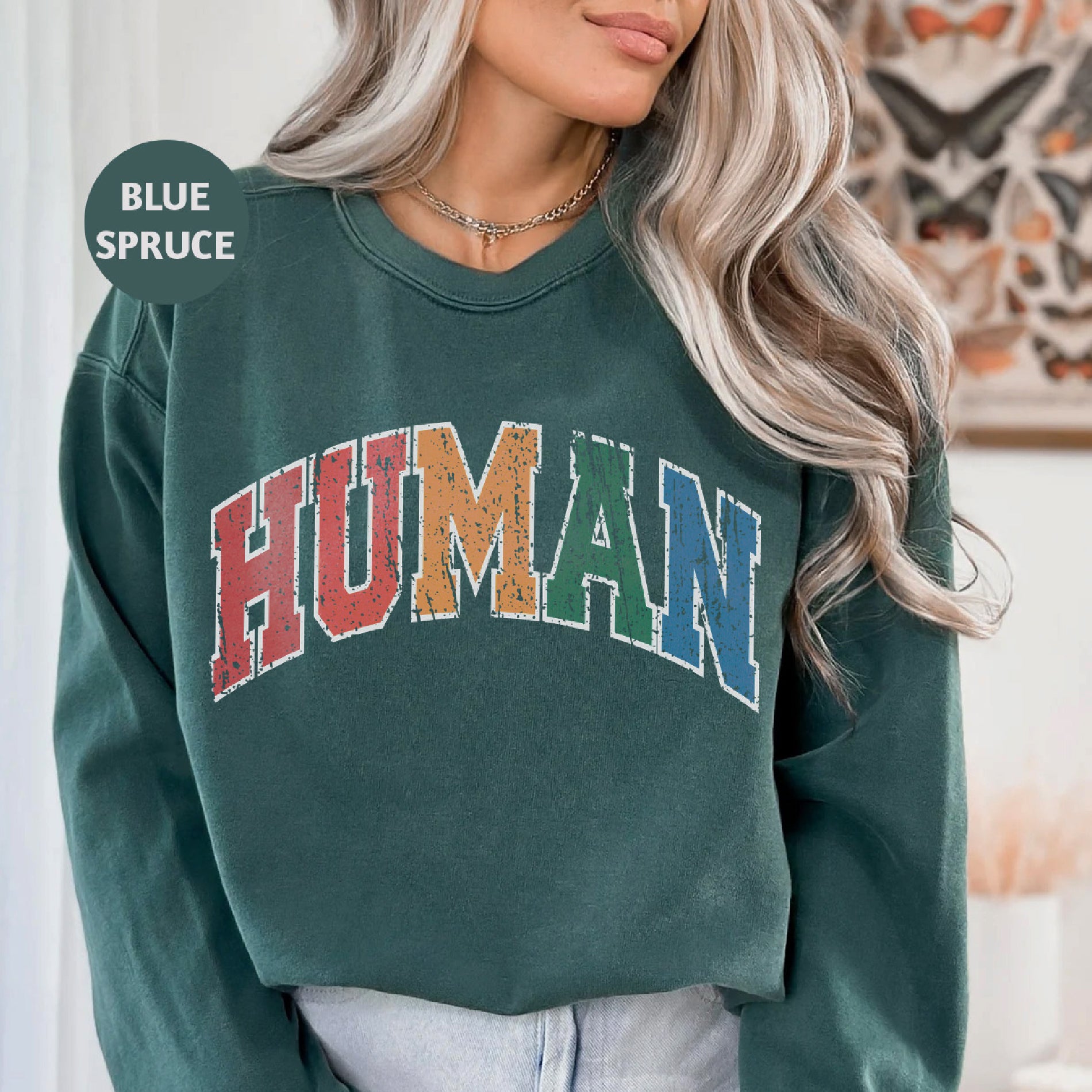 a woman wearing a green sweatshirt with the word human on it