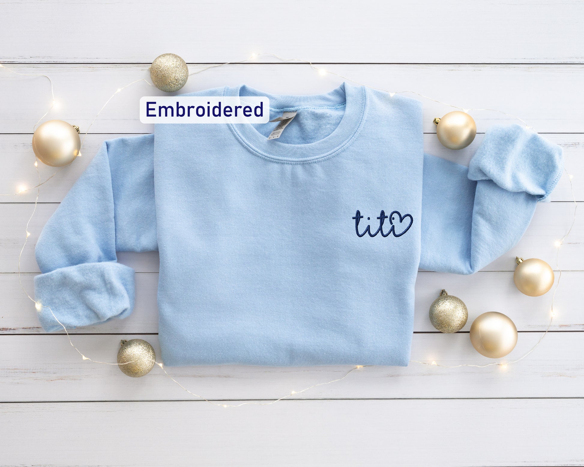 a blue sweater with the word embroidered on it