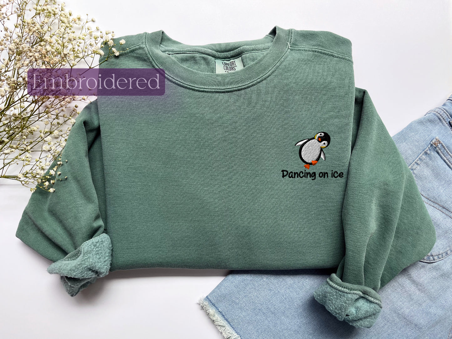 a green sweatshirt with a penguin embroidered on it