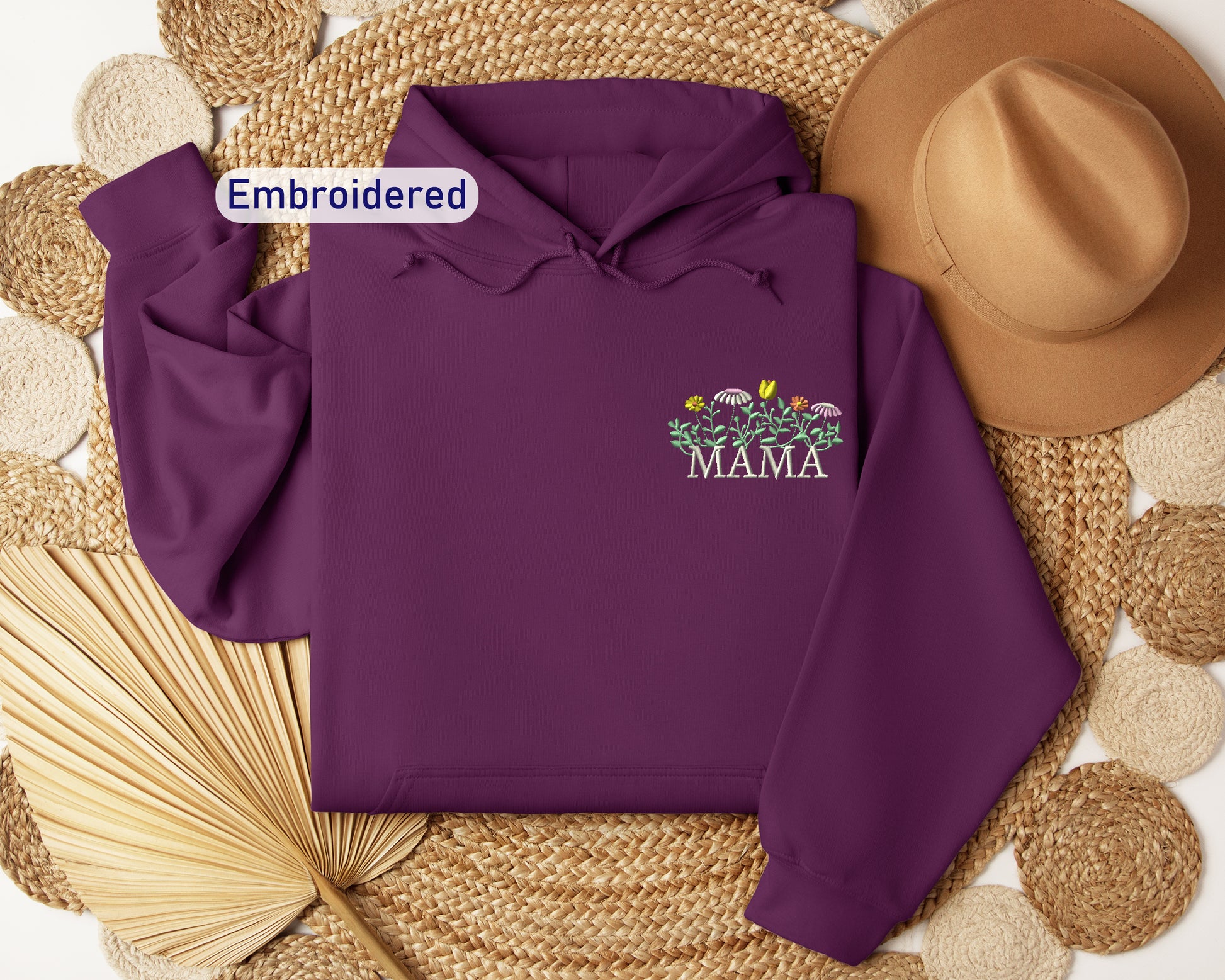 a purple hoodie sitting on top of a straw mat