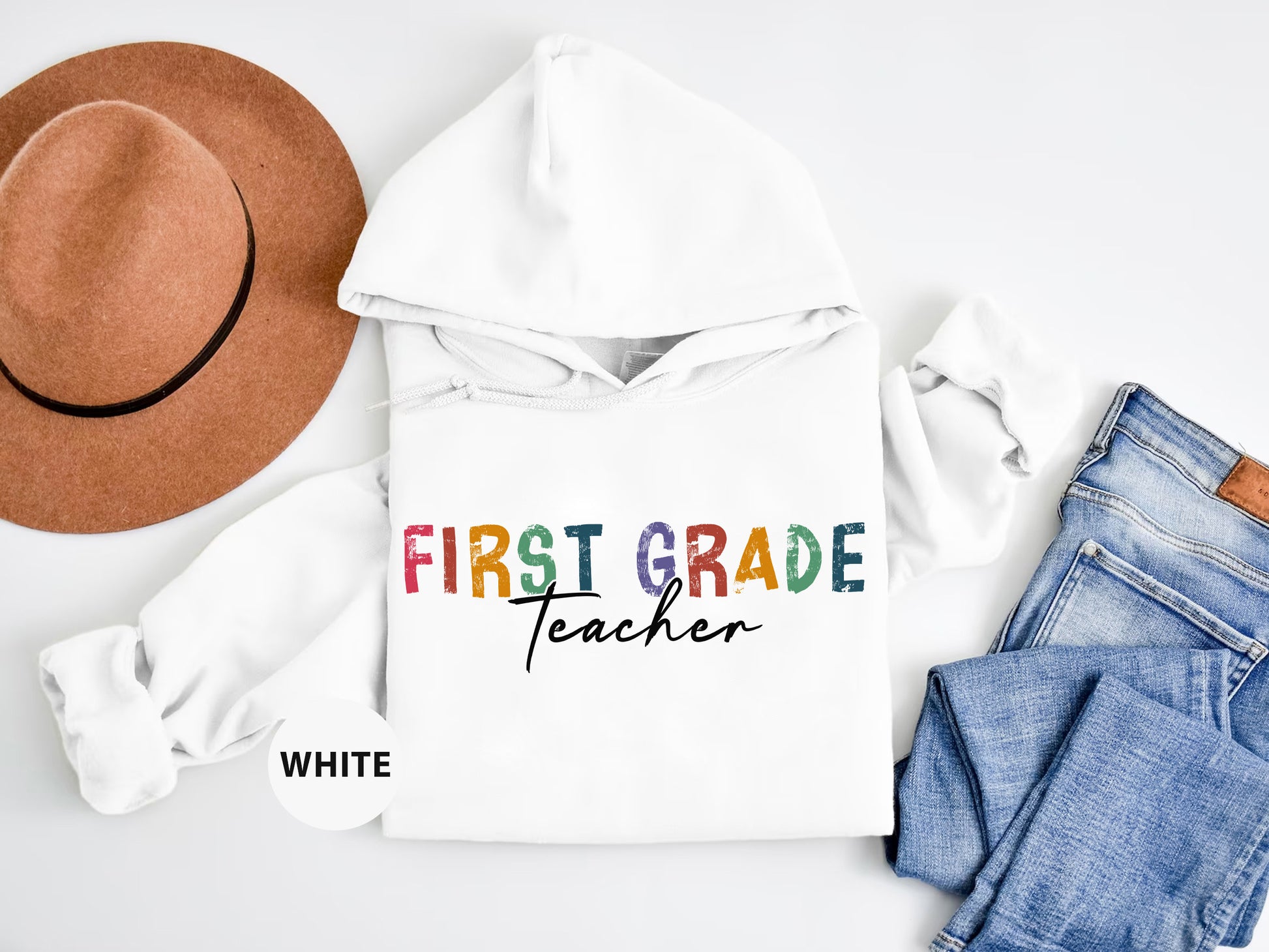 a white hoodie with the words first grade teacher on it