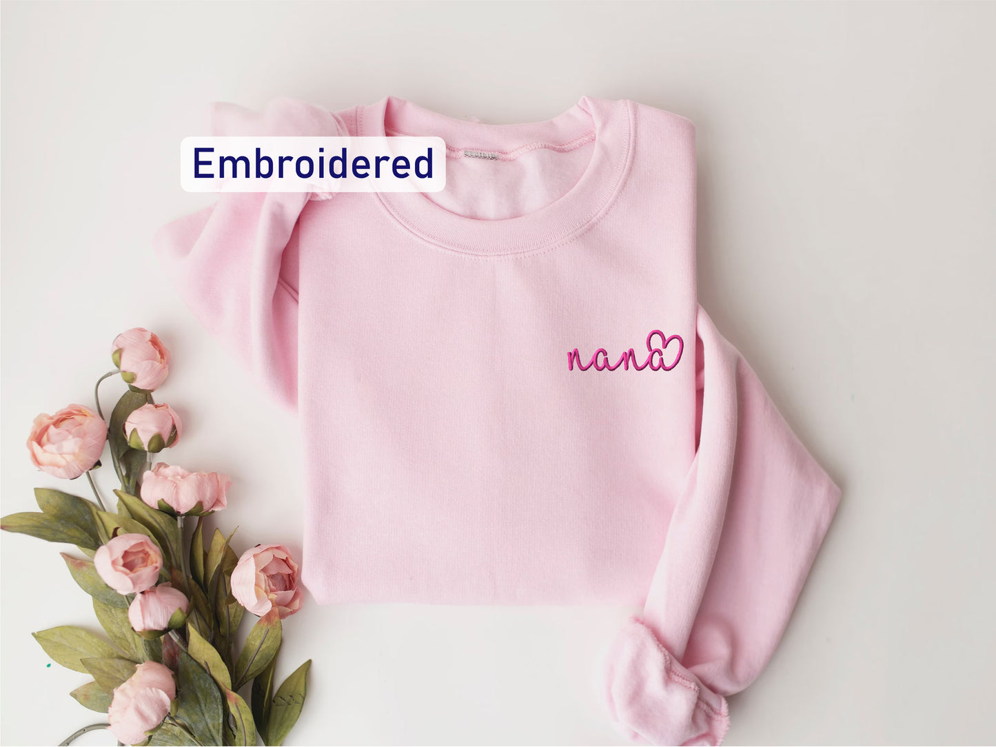 a pink sweater with embroidered name and flowers