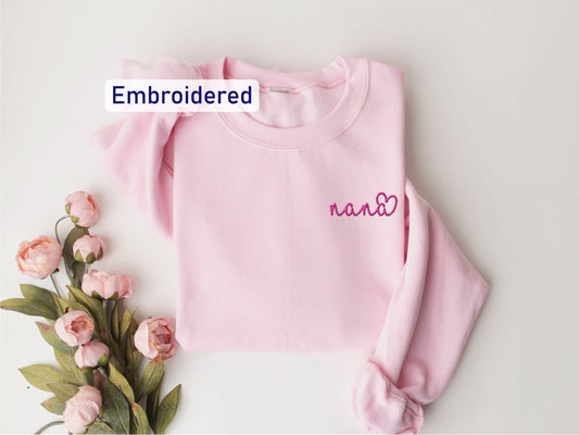 a pink sweater with embroidered name and flowers