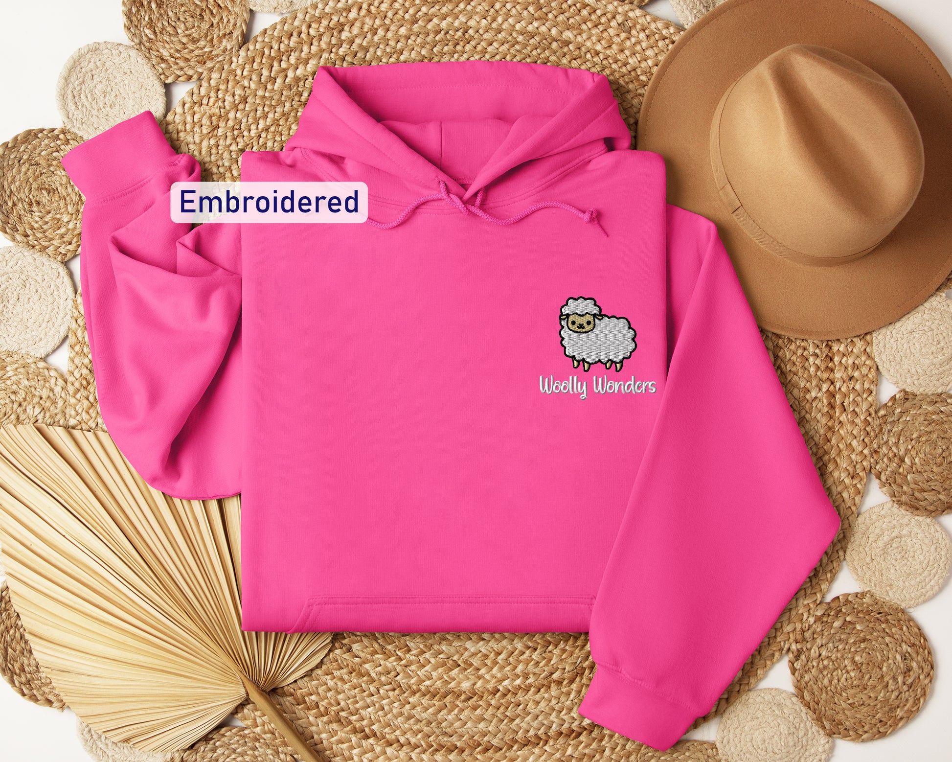 a pink hoodie with a sheep embroidered on it