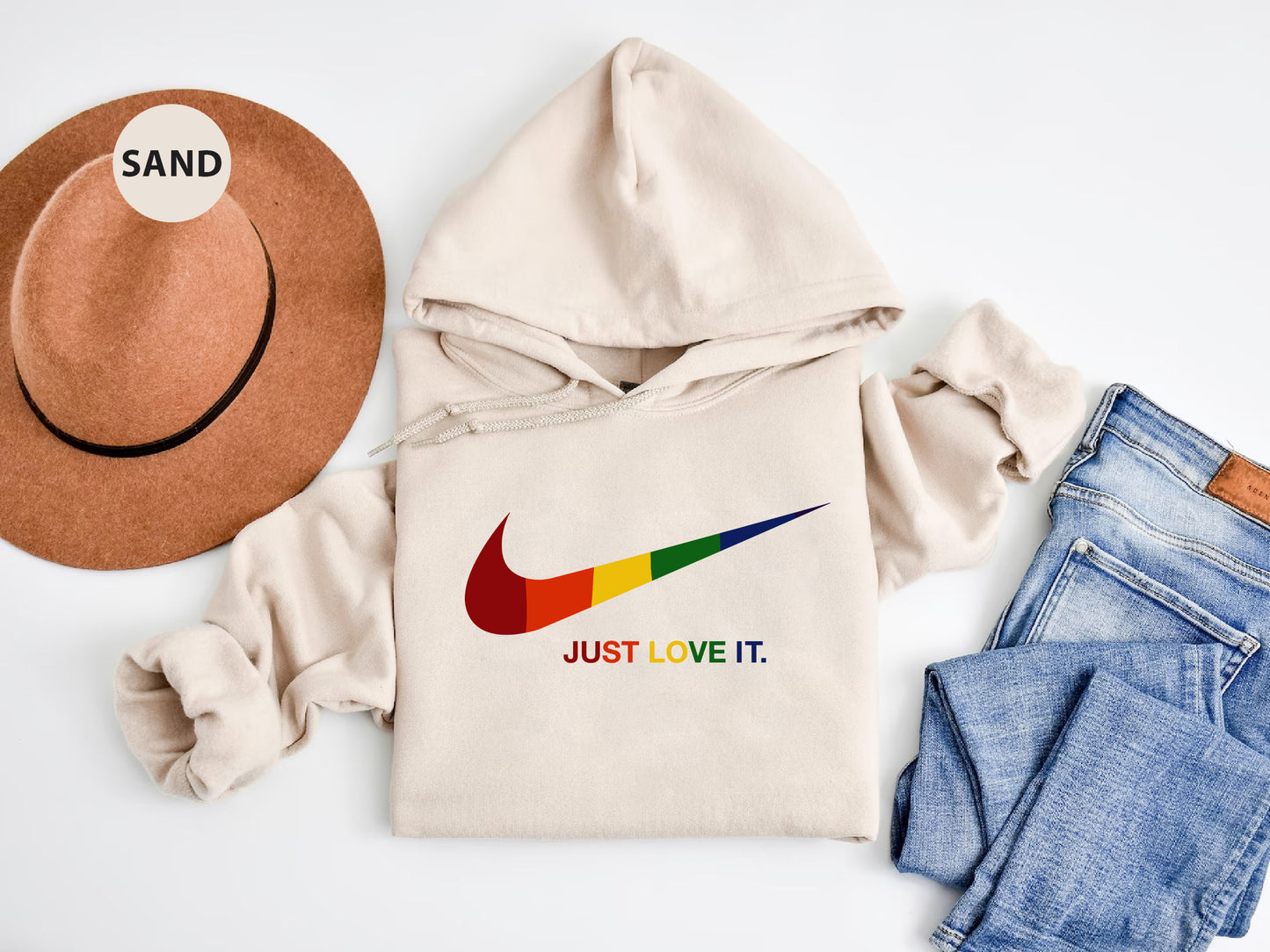 a hat, sweatshirt, jeans, and a pair of shoes on a white surface