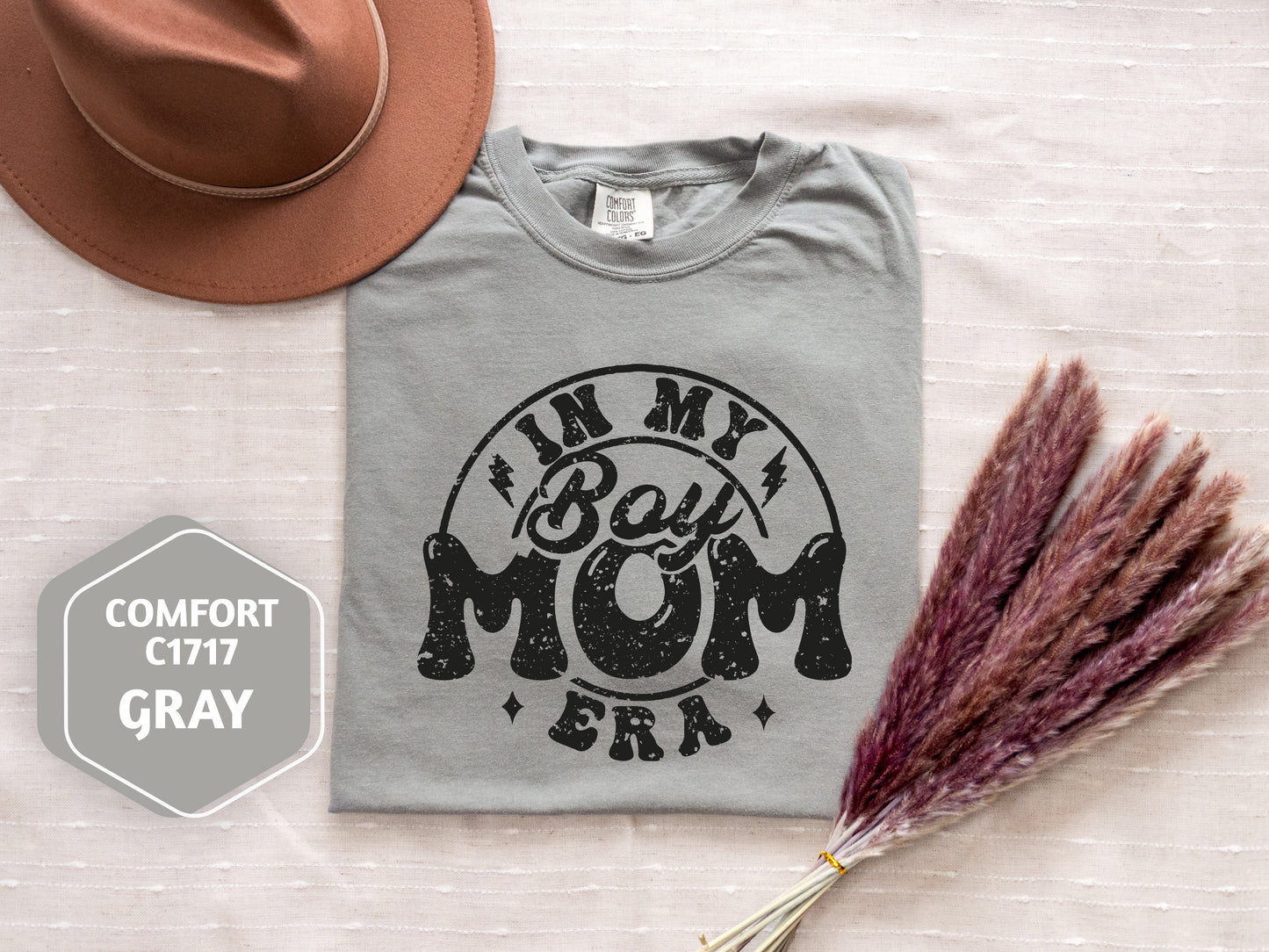 a hat, t - shirt, and dried grass on a bed