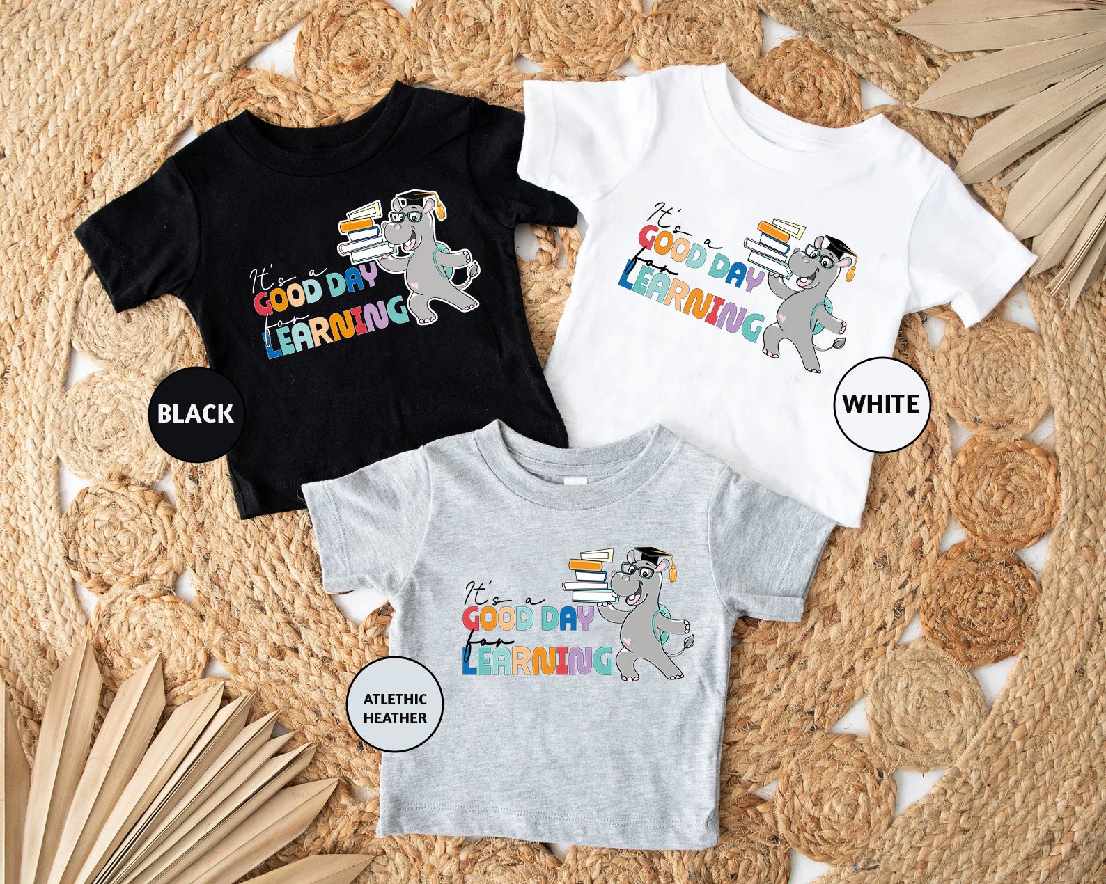 three children's t - shirts on a rug