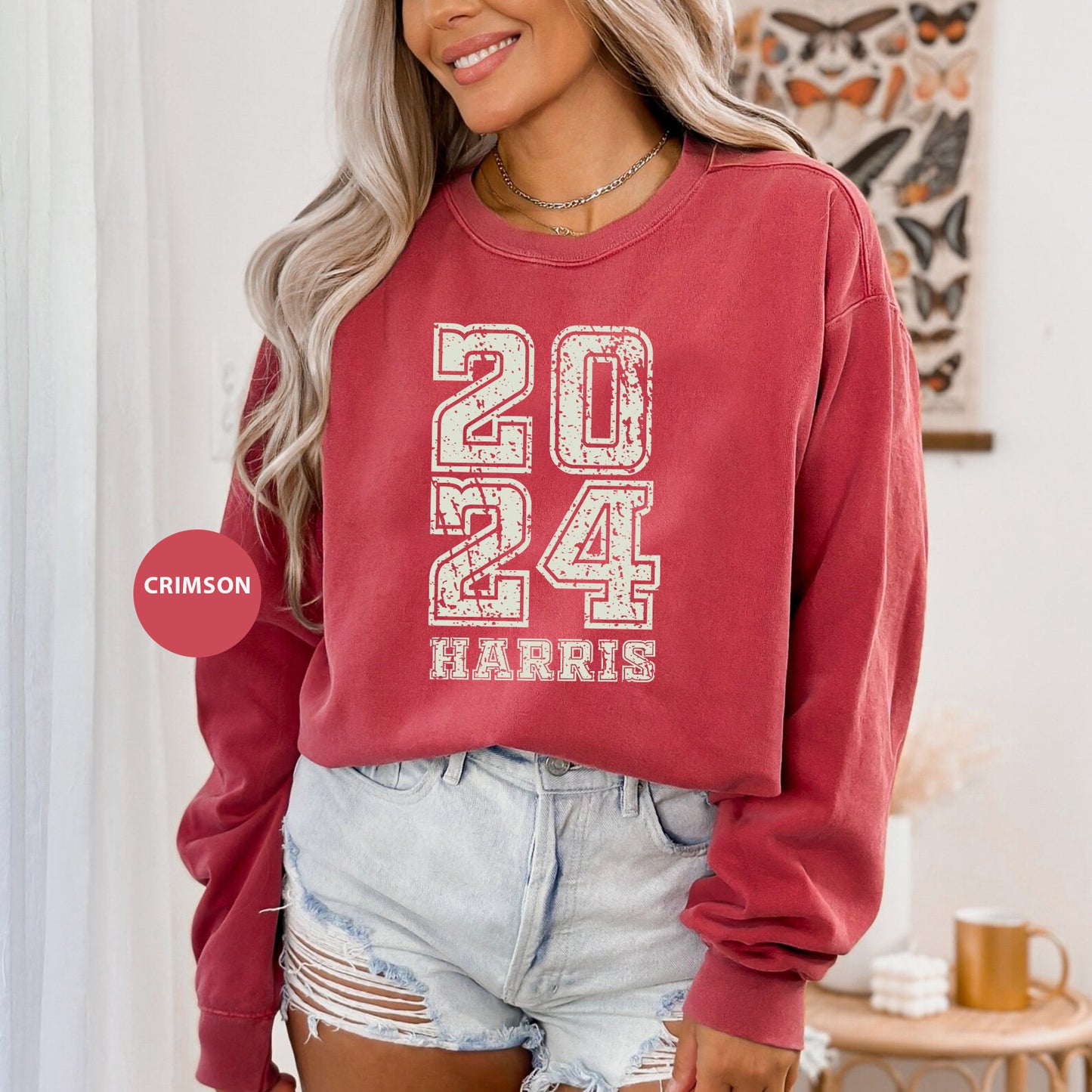 a woman wearing a red sweatshirt and denim shorts