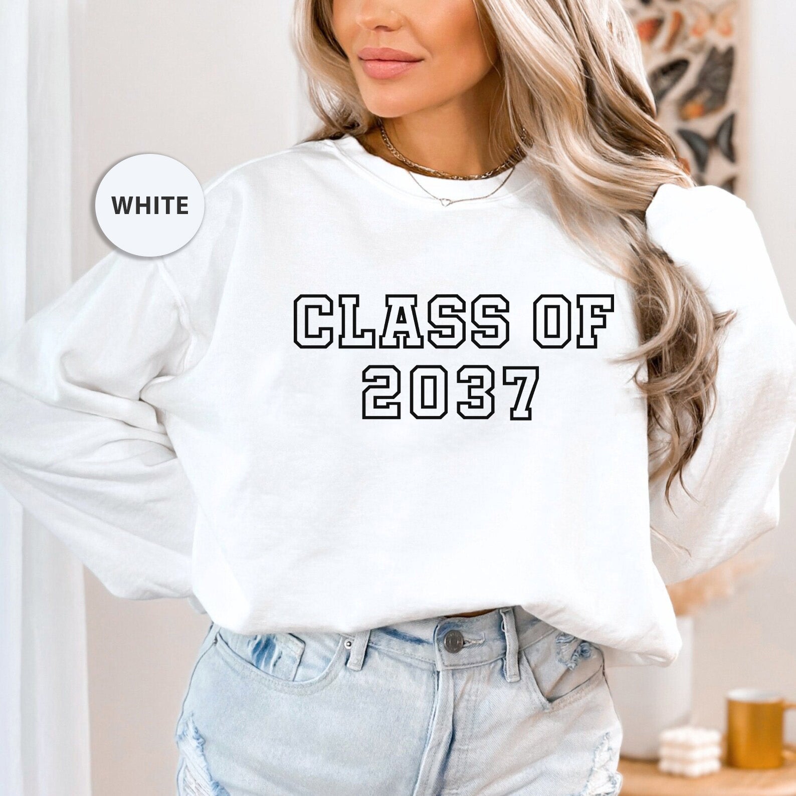 a woman wearing a white sweatshirt that says class of 2077