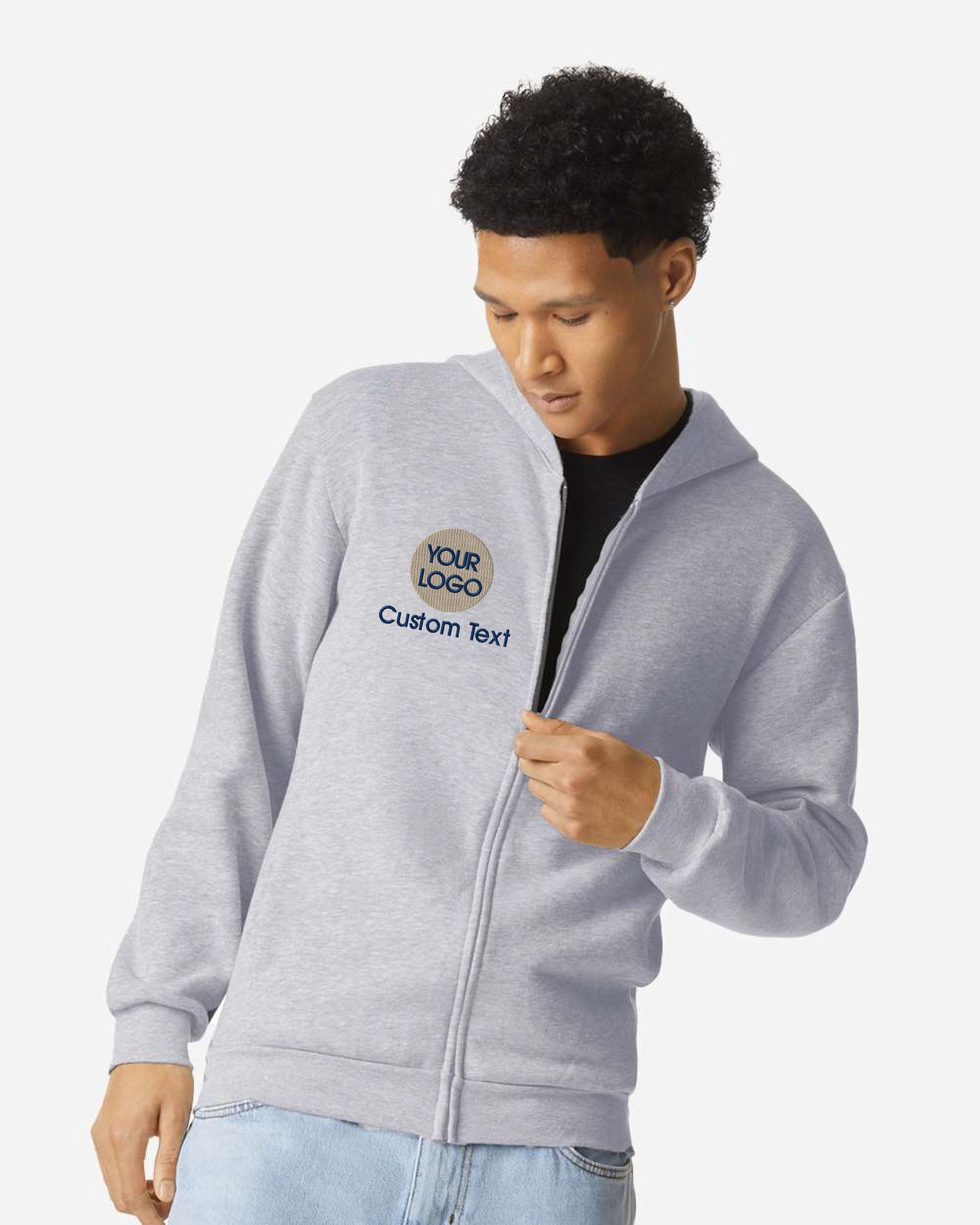 a young man wearing a gray jacket and jeans