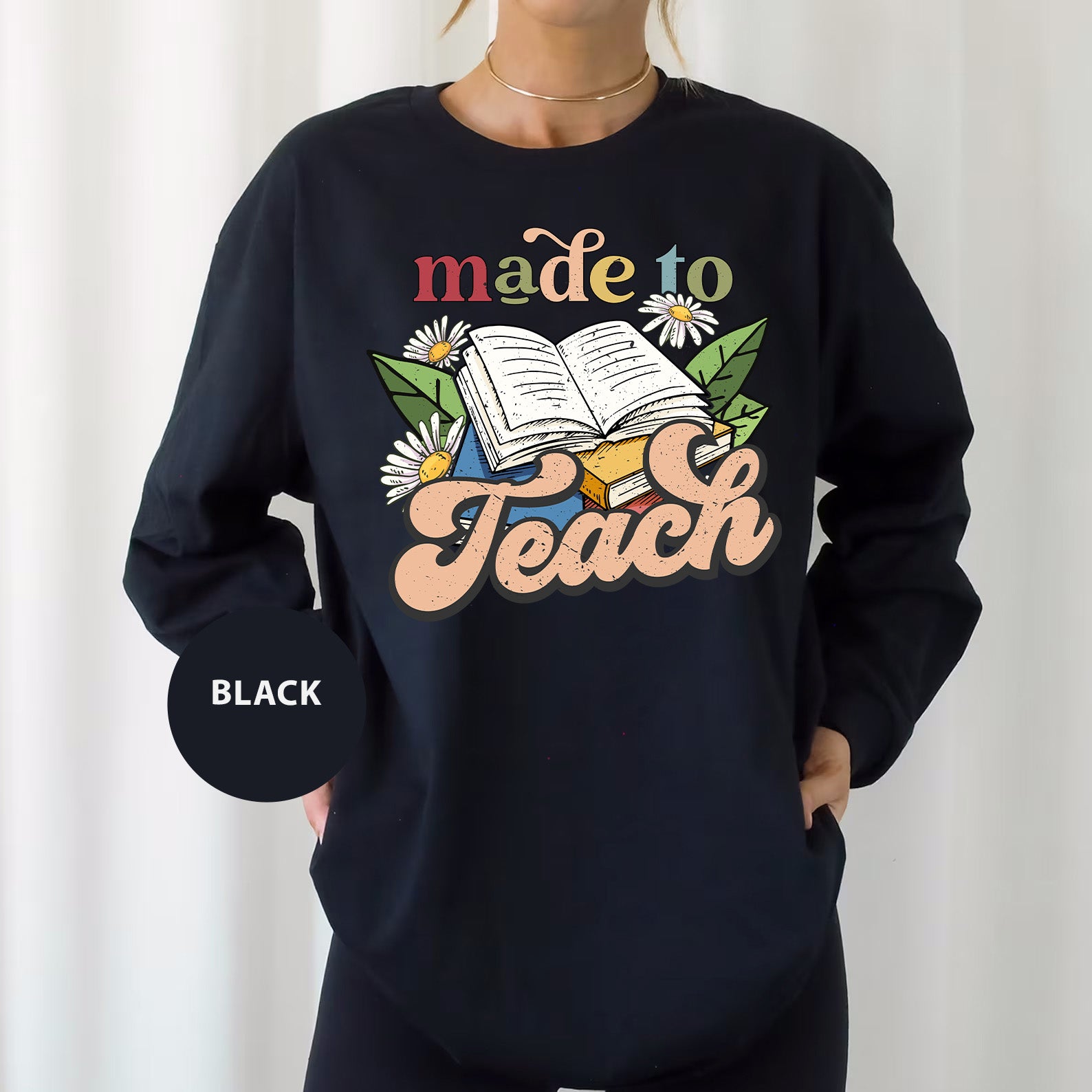 a woman wearing a sweatshirt that says made to teach