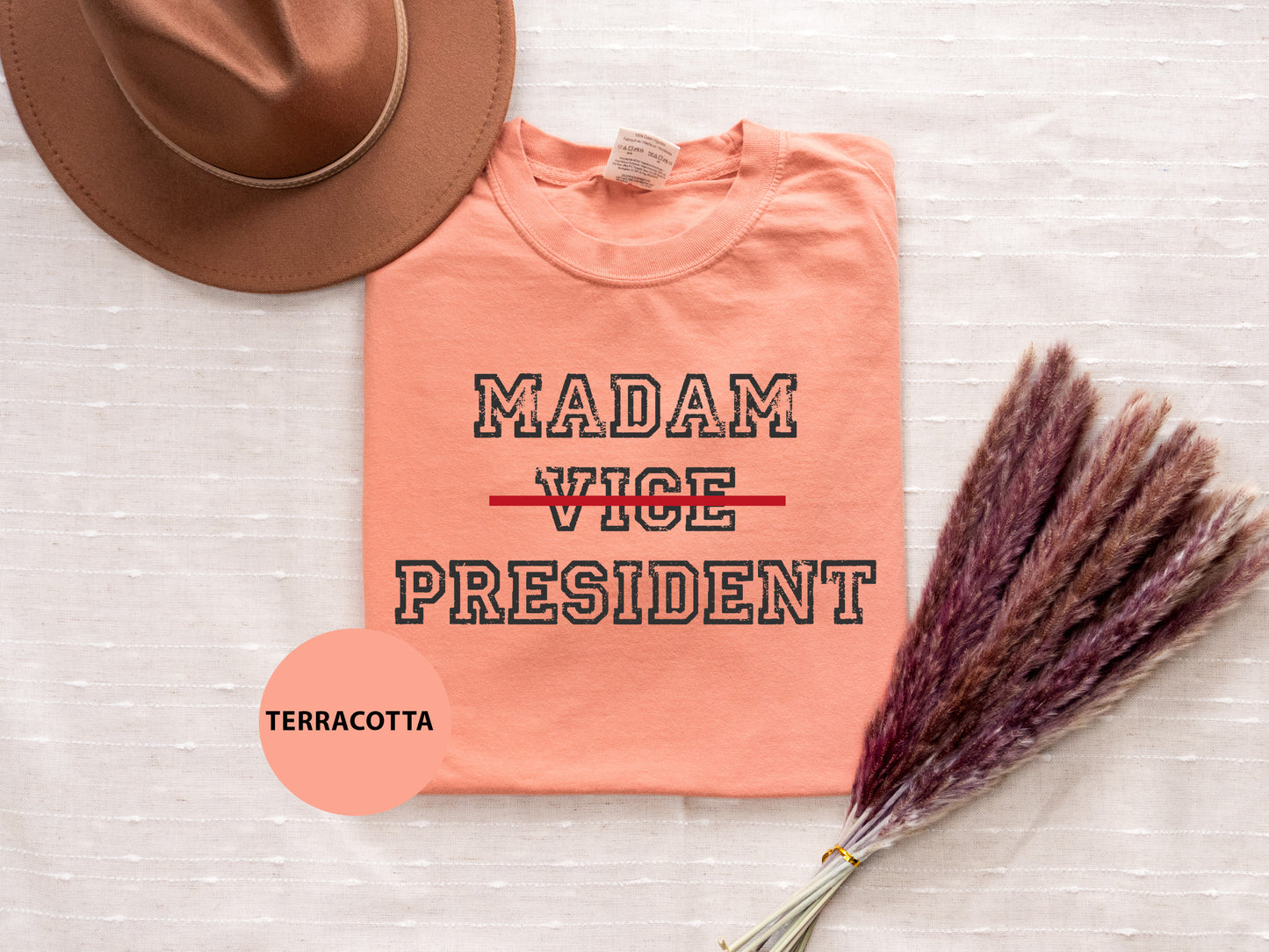 a t - shirt that says madam vice president next to a hat