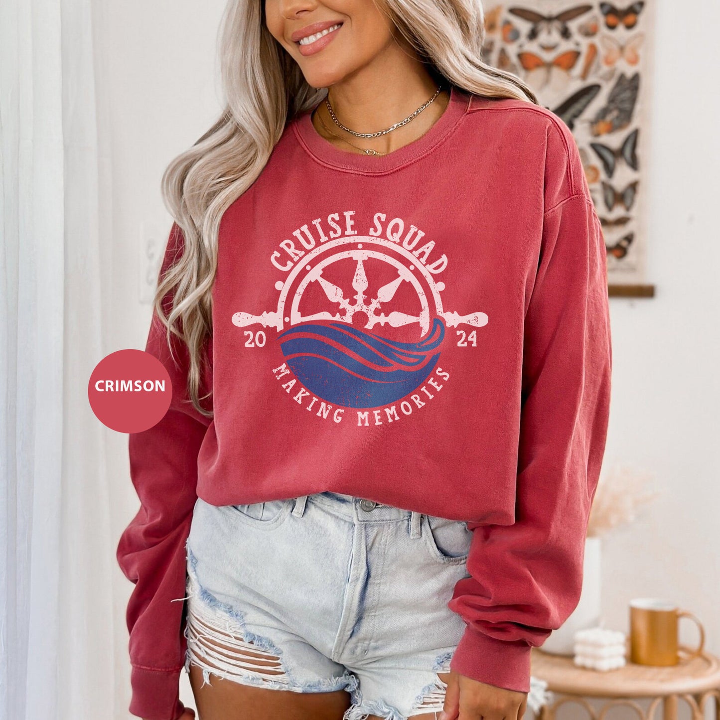 a woman wearing a red sweatshirt and denim shorts