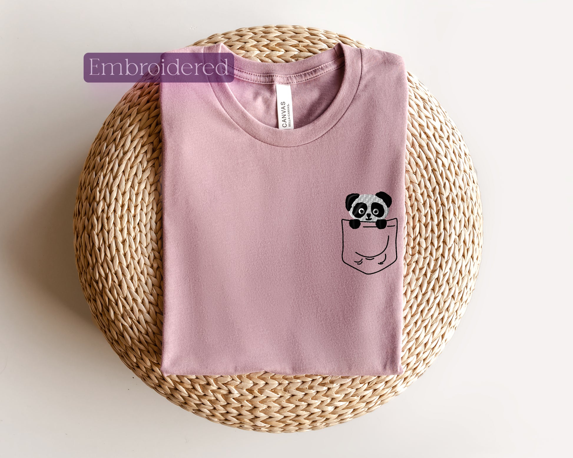 a pink shirt with a panda in a pocket