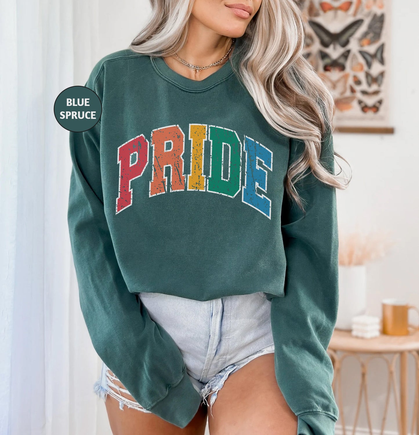 a woman wearing a green sweatshirt with the word pride on it