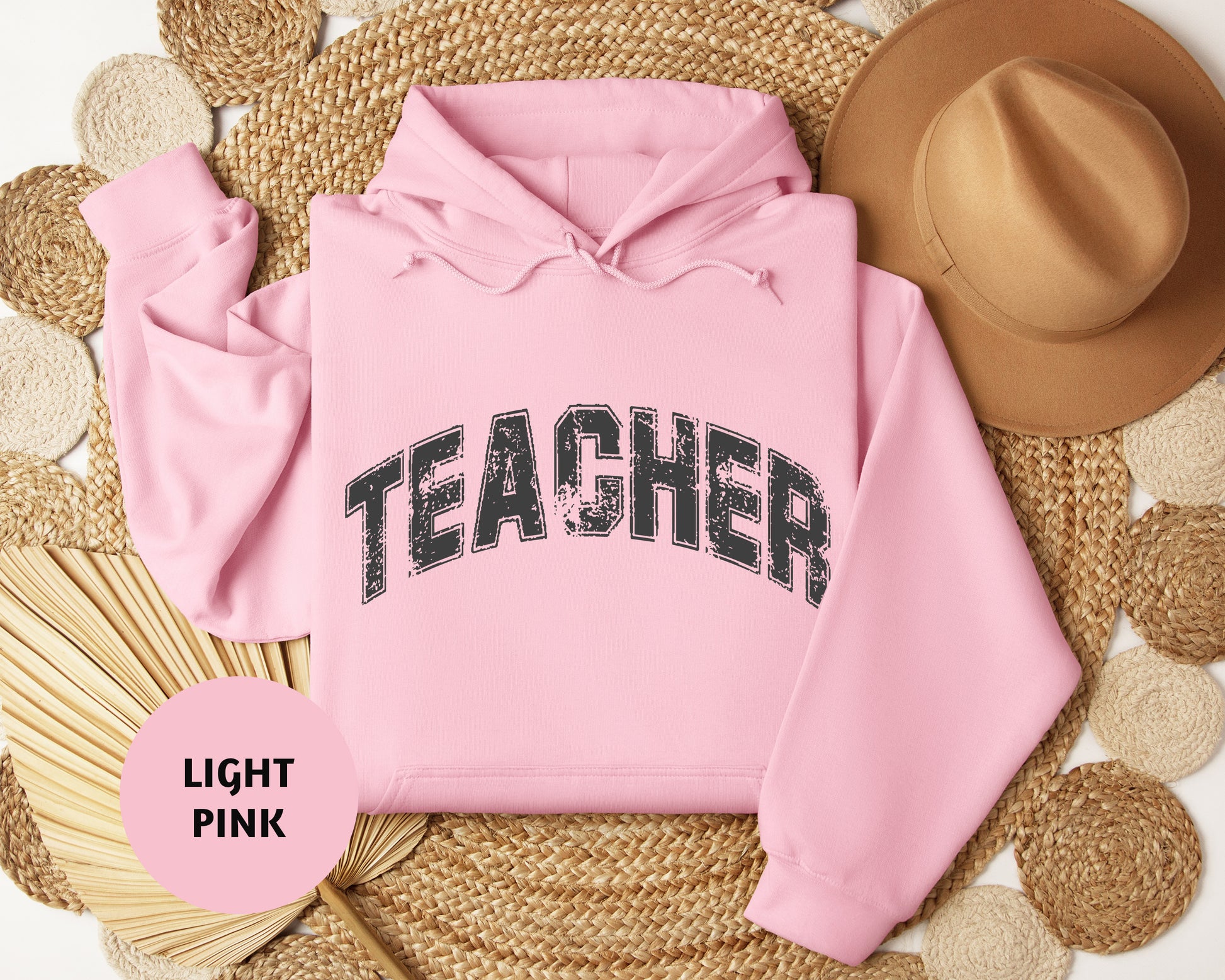 a pink hoodie with the word teacher printed on it
