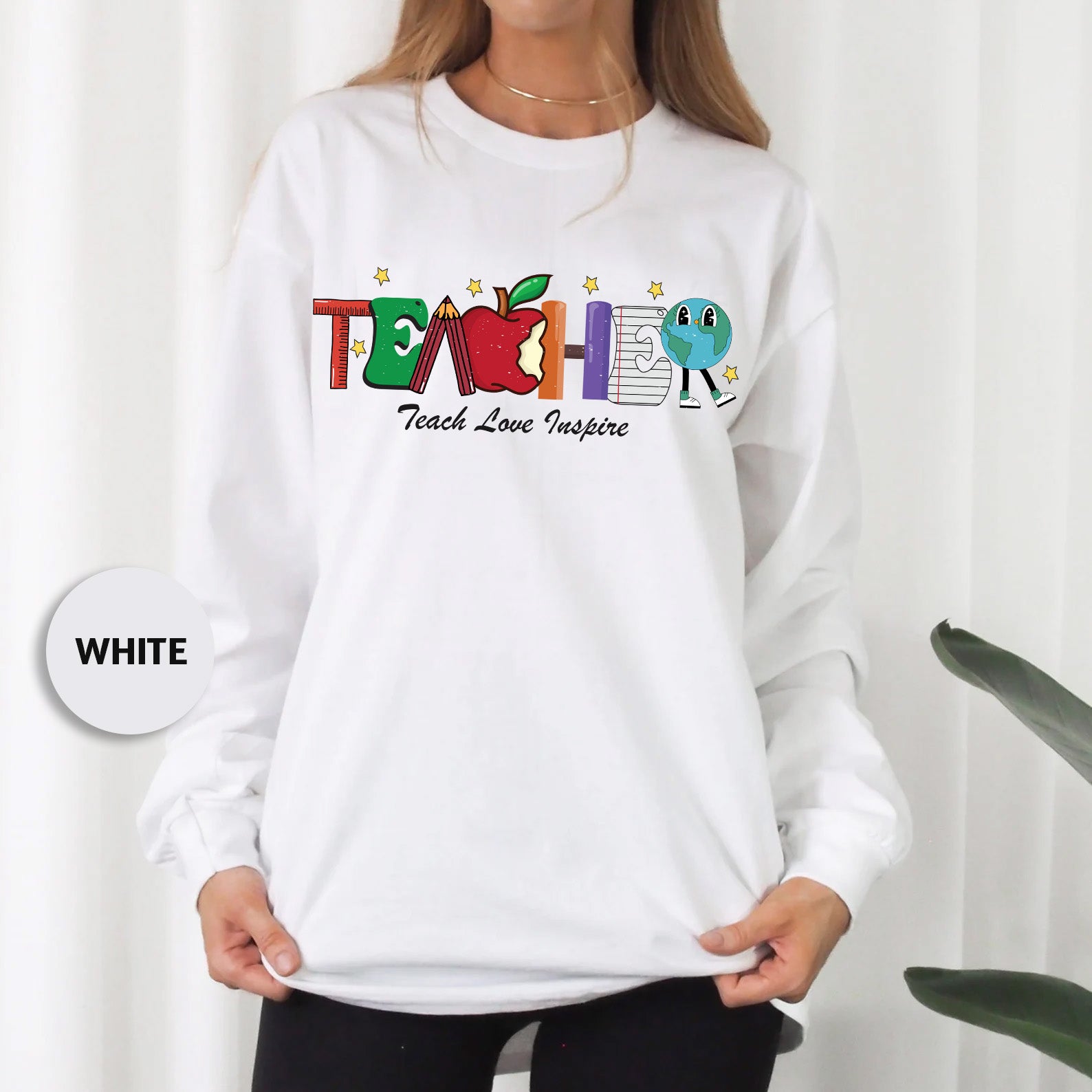 a woman wearing a white teacher's love jumper
