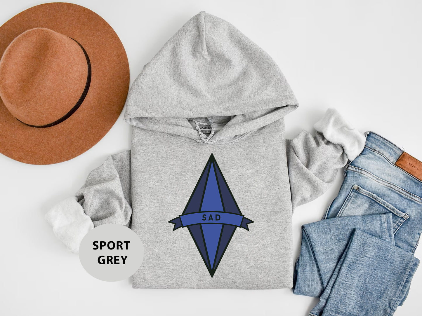 a hat, sweatshirt, jeans, and a pair of shoes on a white surface