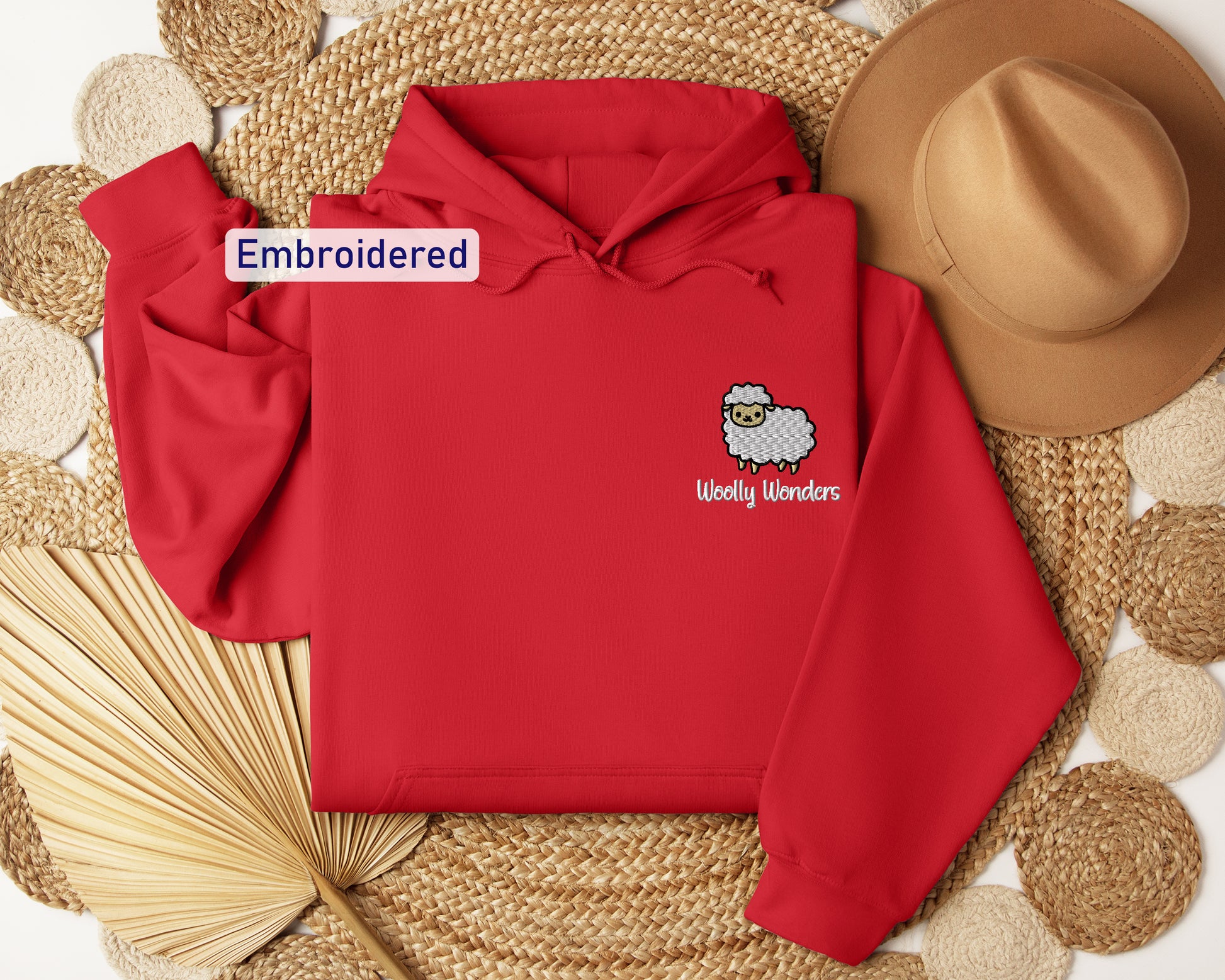a red hoodie with an embroidered sheep on it