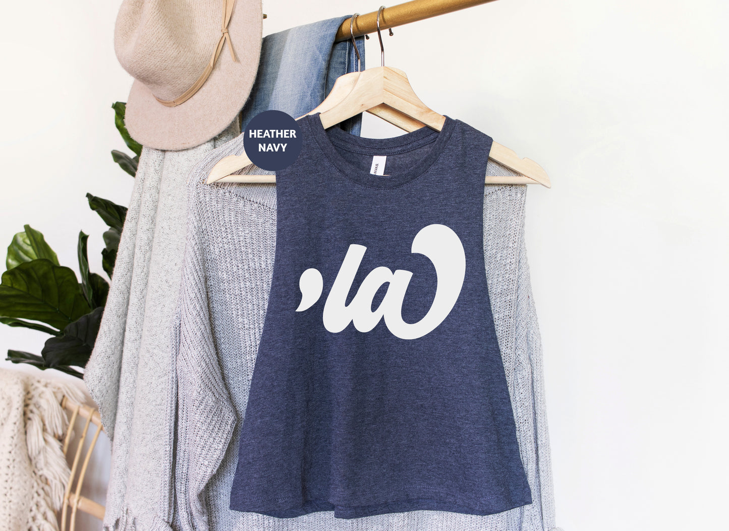 a t - shirt hanging on a clothes rack next to a hat