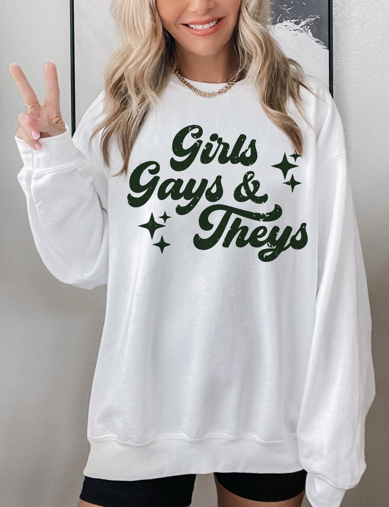 a woman wearing a white sweatshirt and black shorts