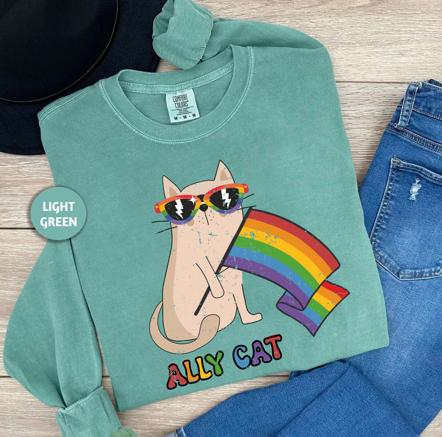 a green shirt with a cat wearing sunglasses