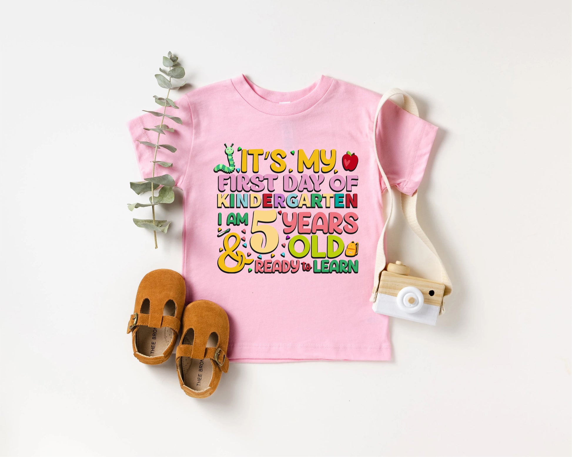 a pink shirt with a pair of sandals and a camera