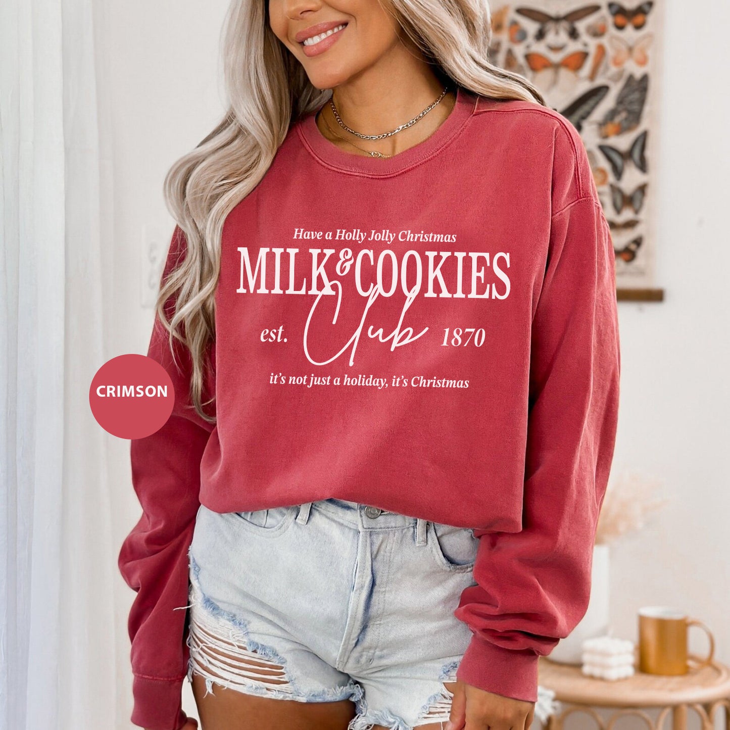 a woman wearing a red sweatshirt and denim shorts