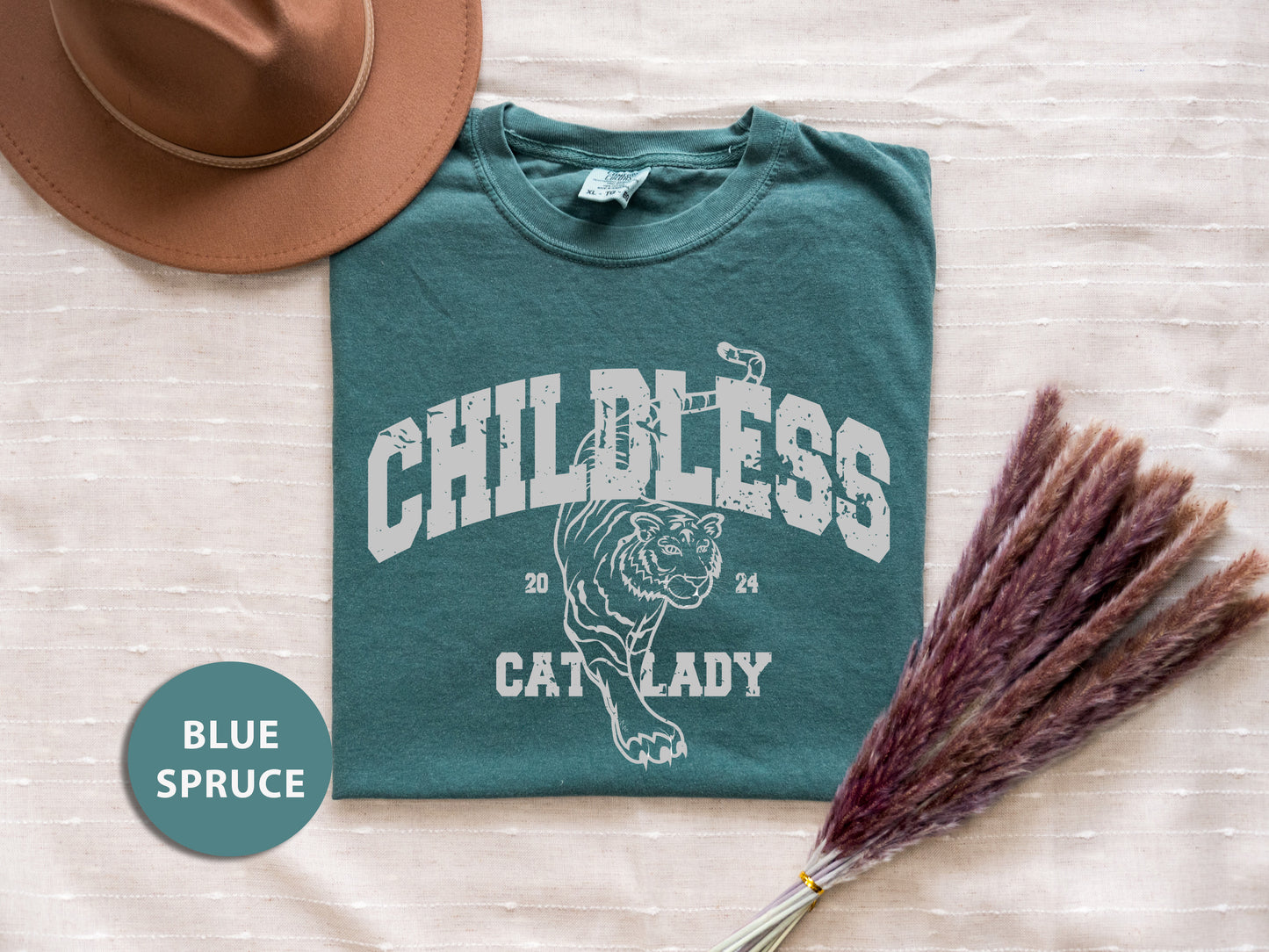 a hat, t - shirt, and broom laying on a bed