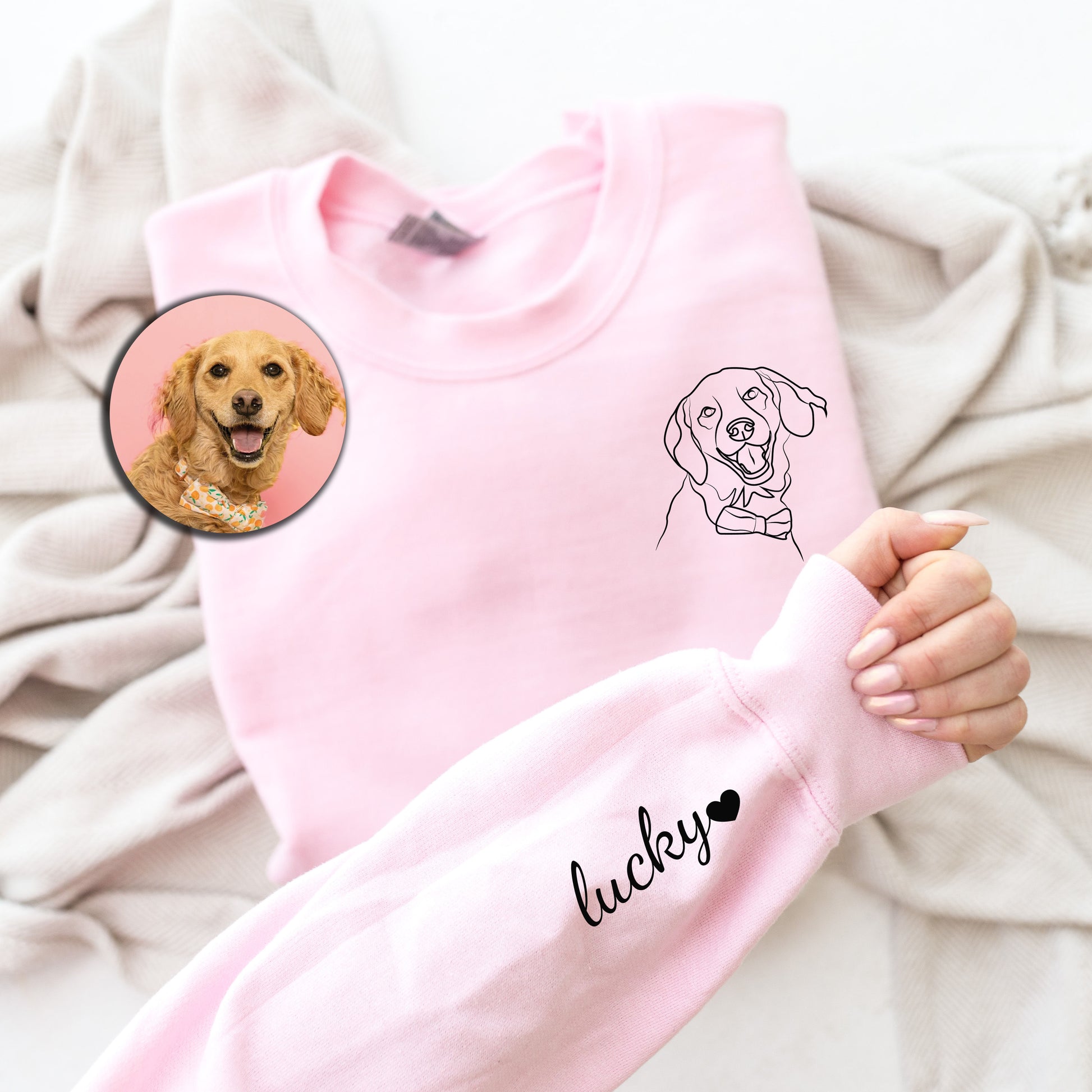 a person holding a pink sweater with a picture of a dog on it