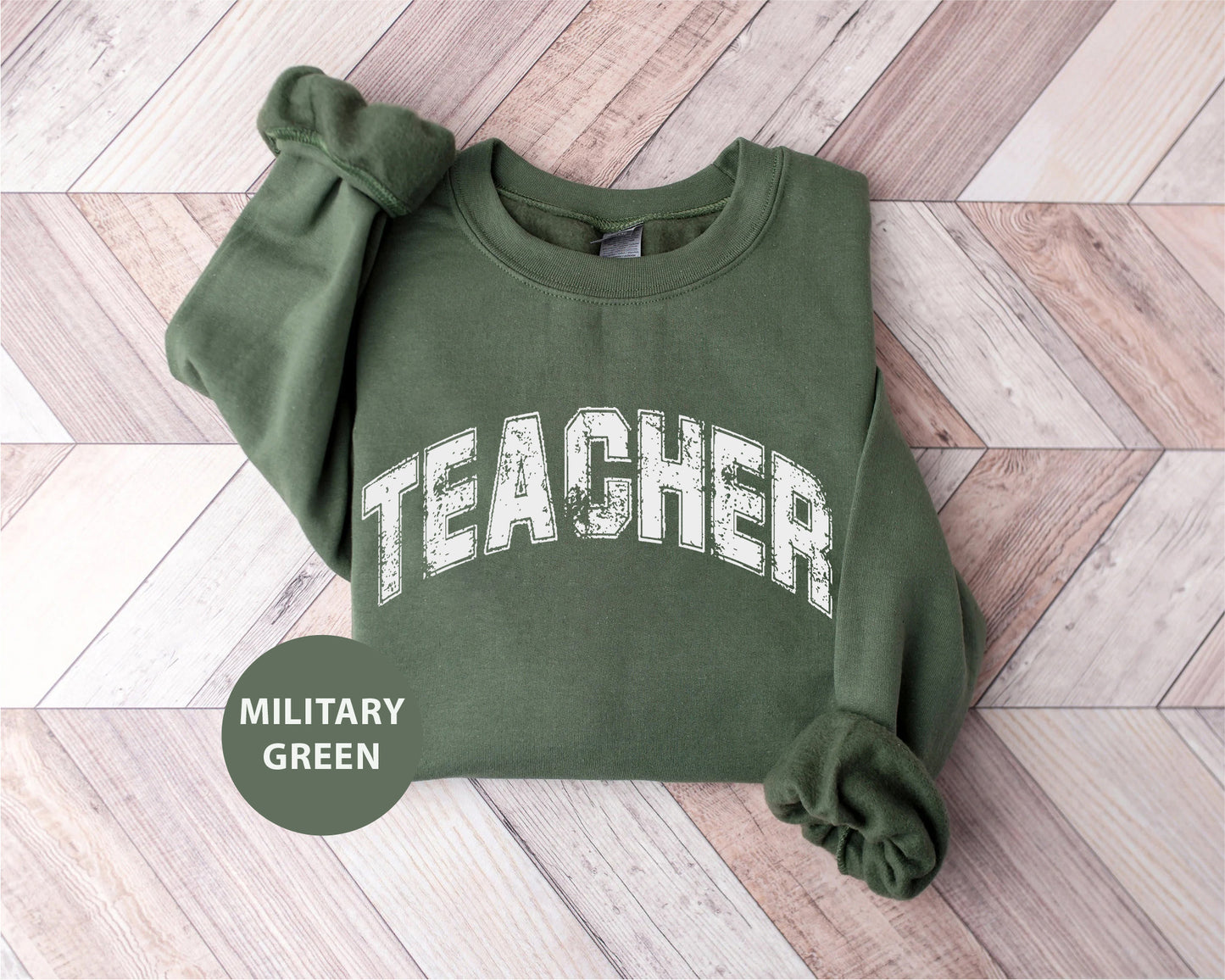a green sweatshirt with the word teacher printed on it