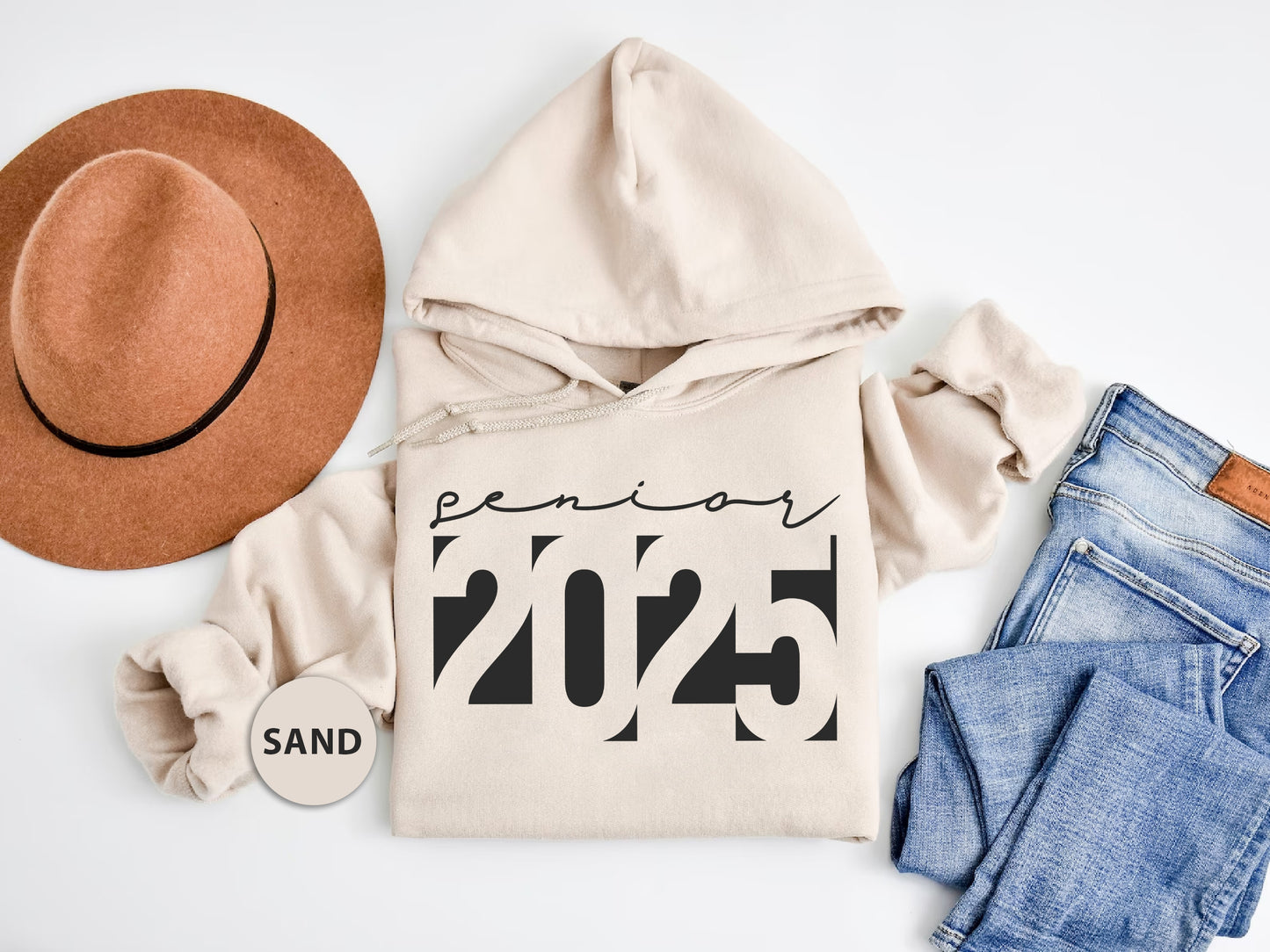 a pair of jeans, a hat, and a sweatshirt on a white surface