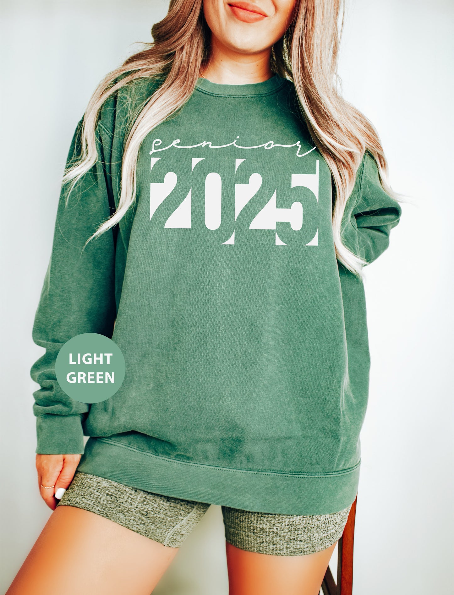 a woman wearing a green sweatshirt and shorts