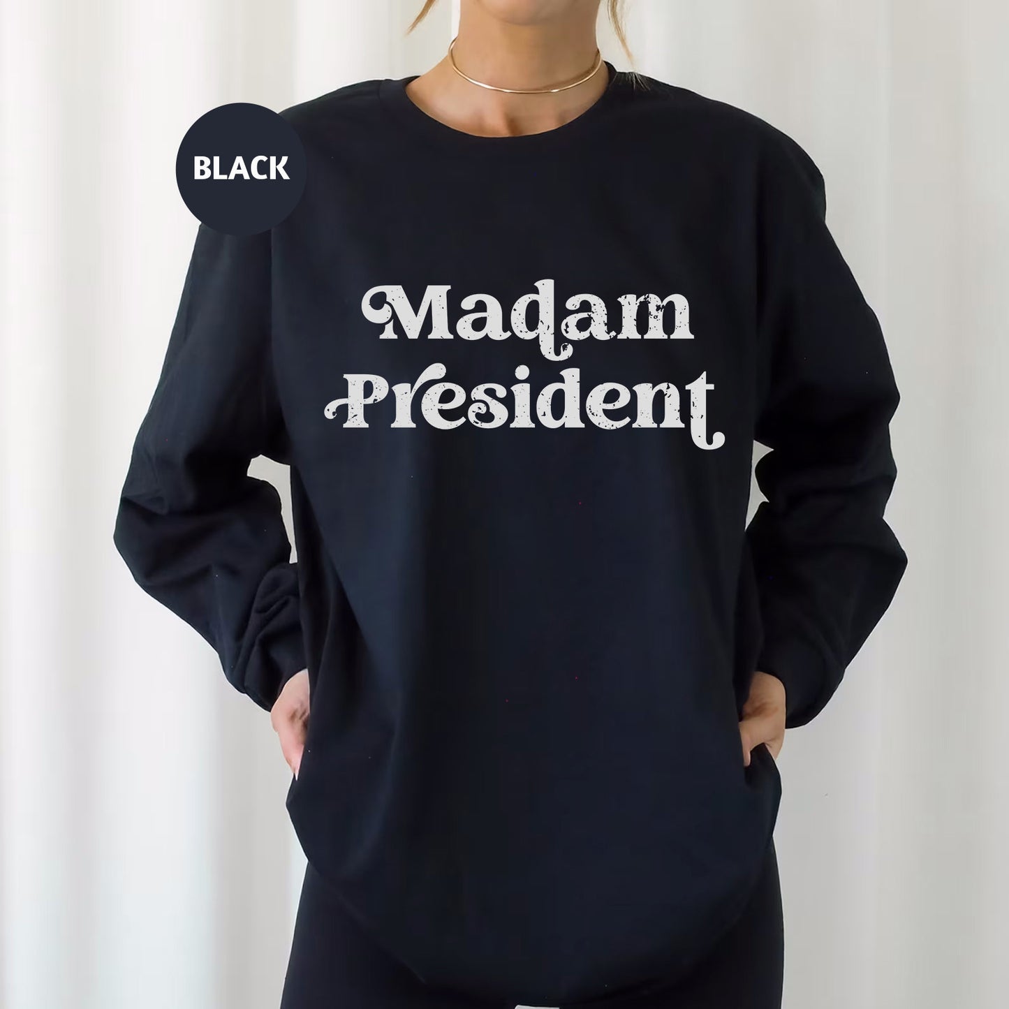 a woman wearing a black sweatshirt that says madam president