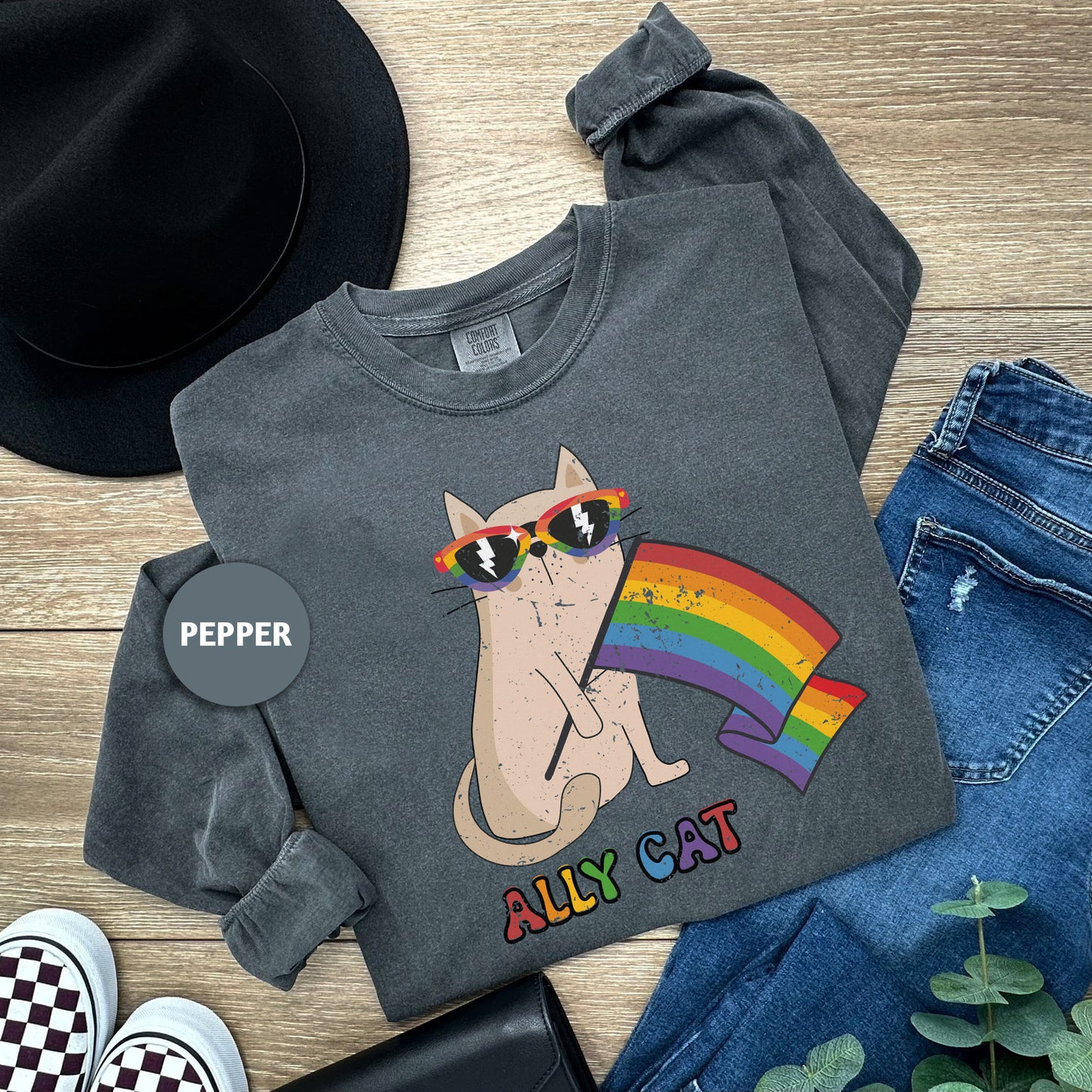 a cat wearing sunglasses and a rainbow t - shirt