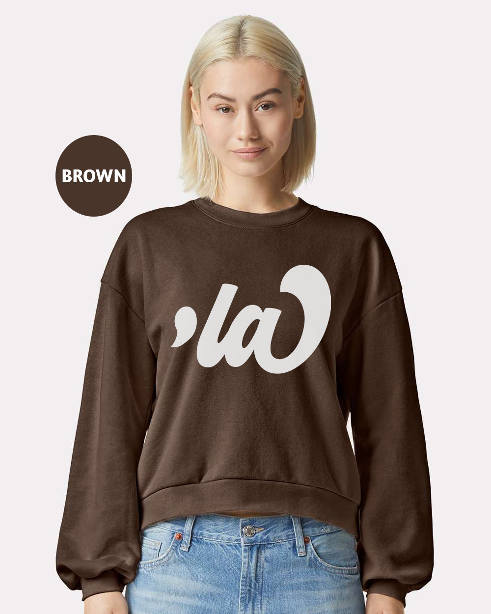 a woman with blonde hair wearing a brown sweatshirt