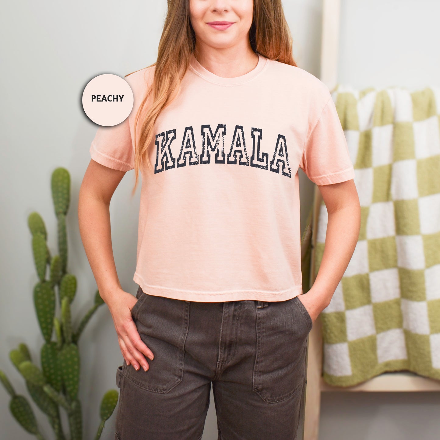 a woman standing in front of a cactus with her hands on her hips