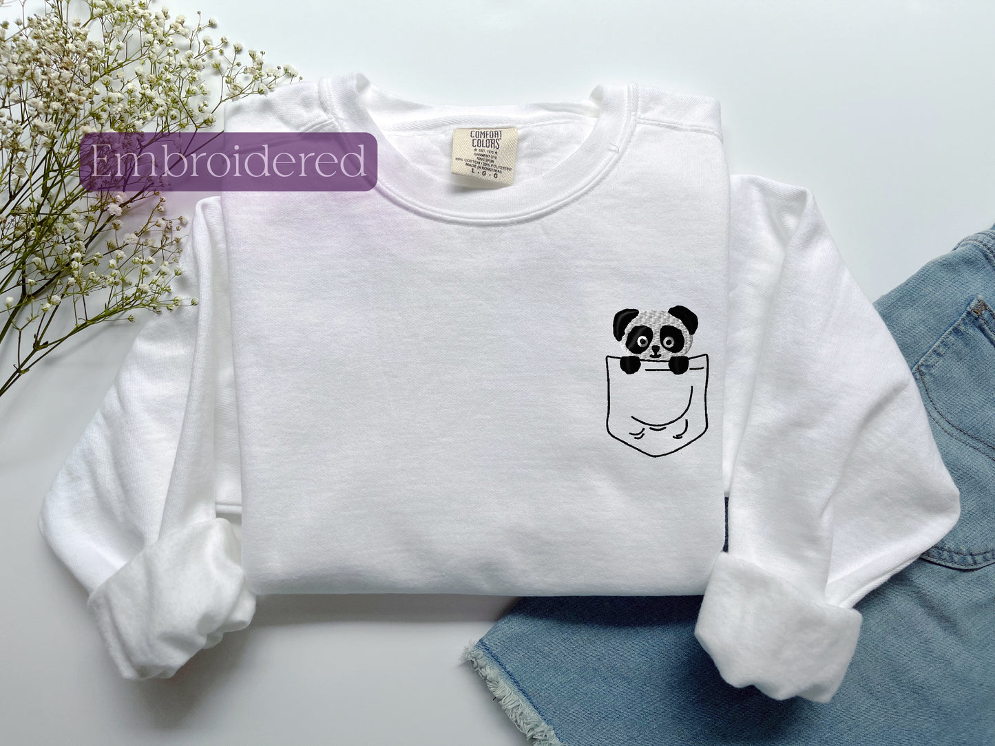 a white shirt with a panda in a pocket
