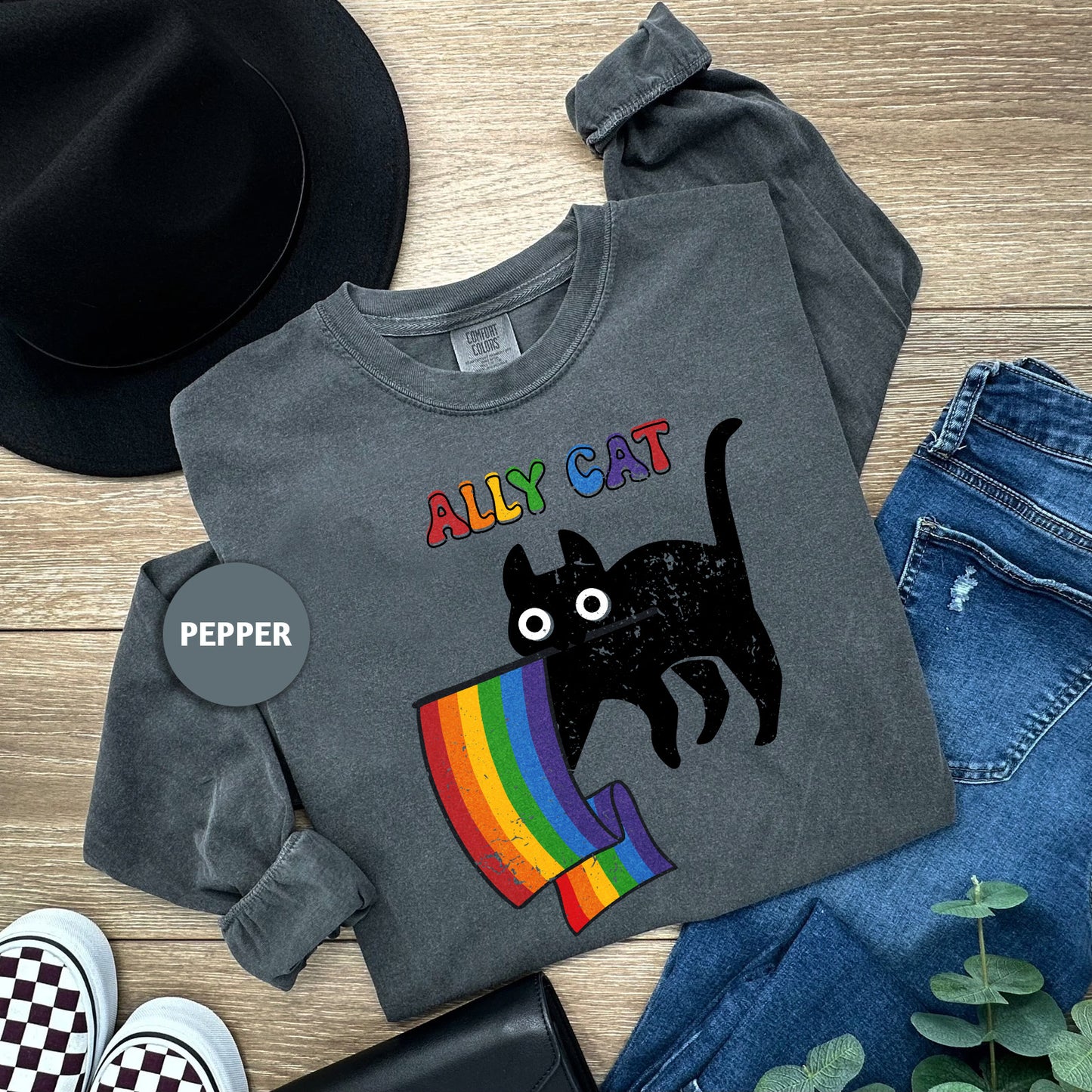 a black cat on a rainbow t - shirt with a black hat, jeans,