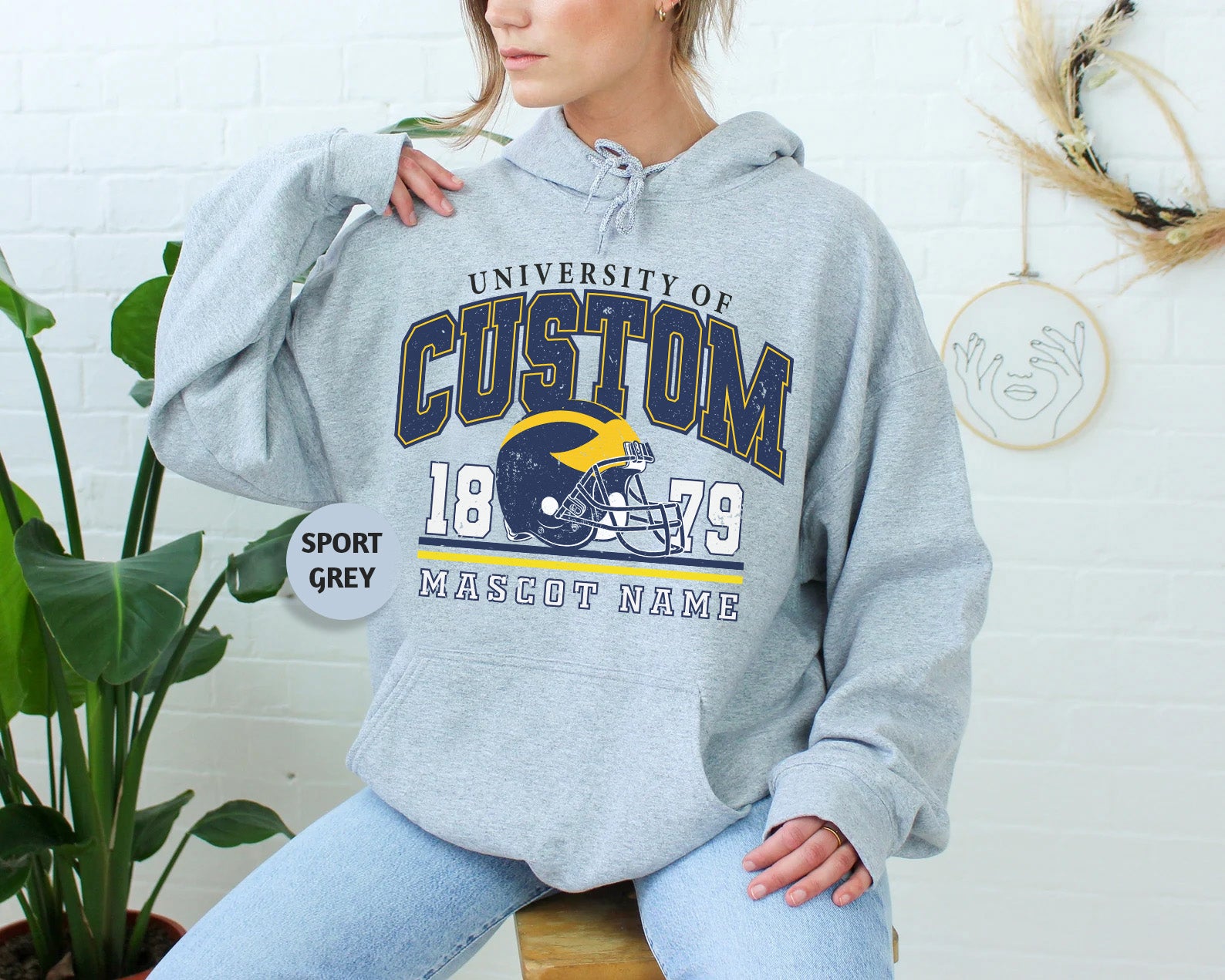 a woman sitting on a stool wearing a hoodie