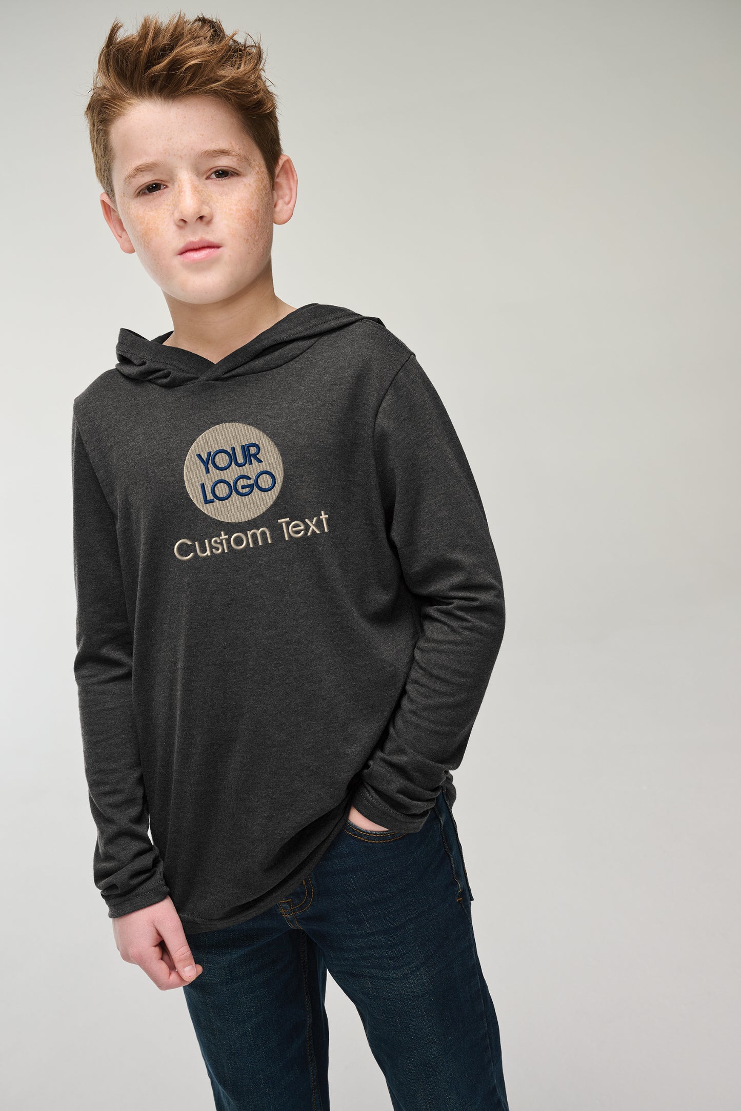 a young boy wearing a black hoodie and jeans