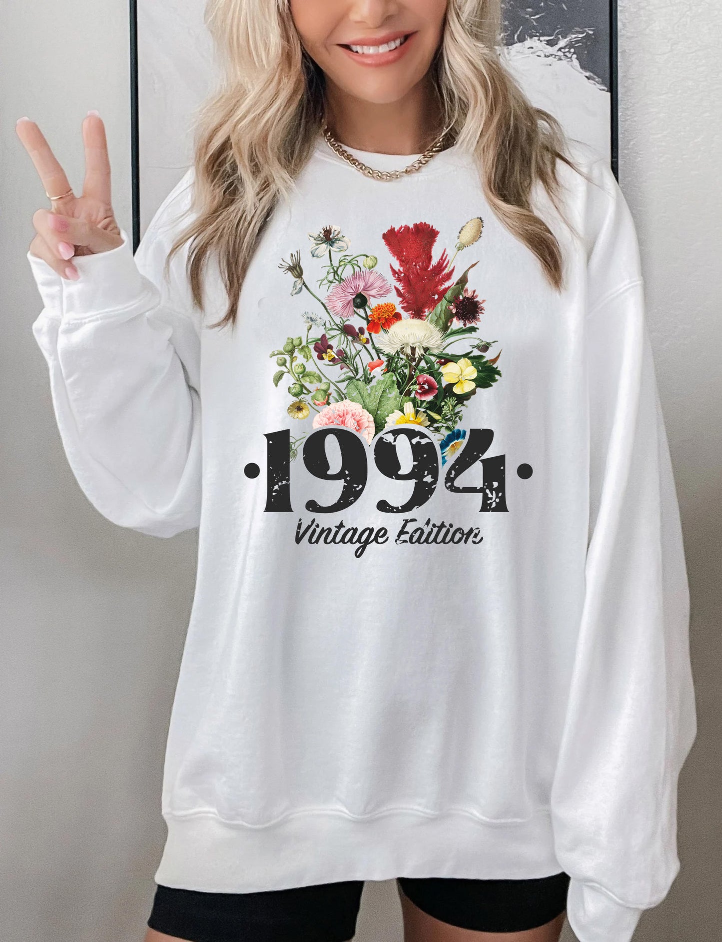 a woman wearing a white sweatshirt and black shorts