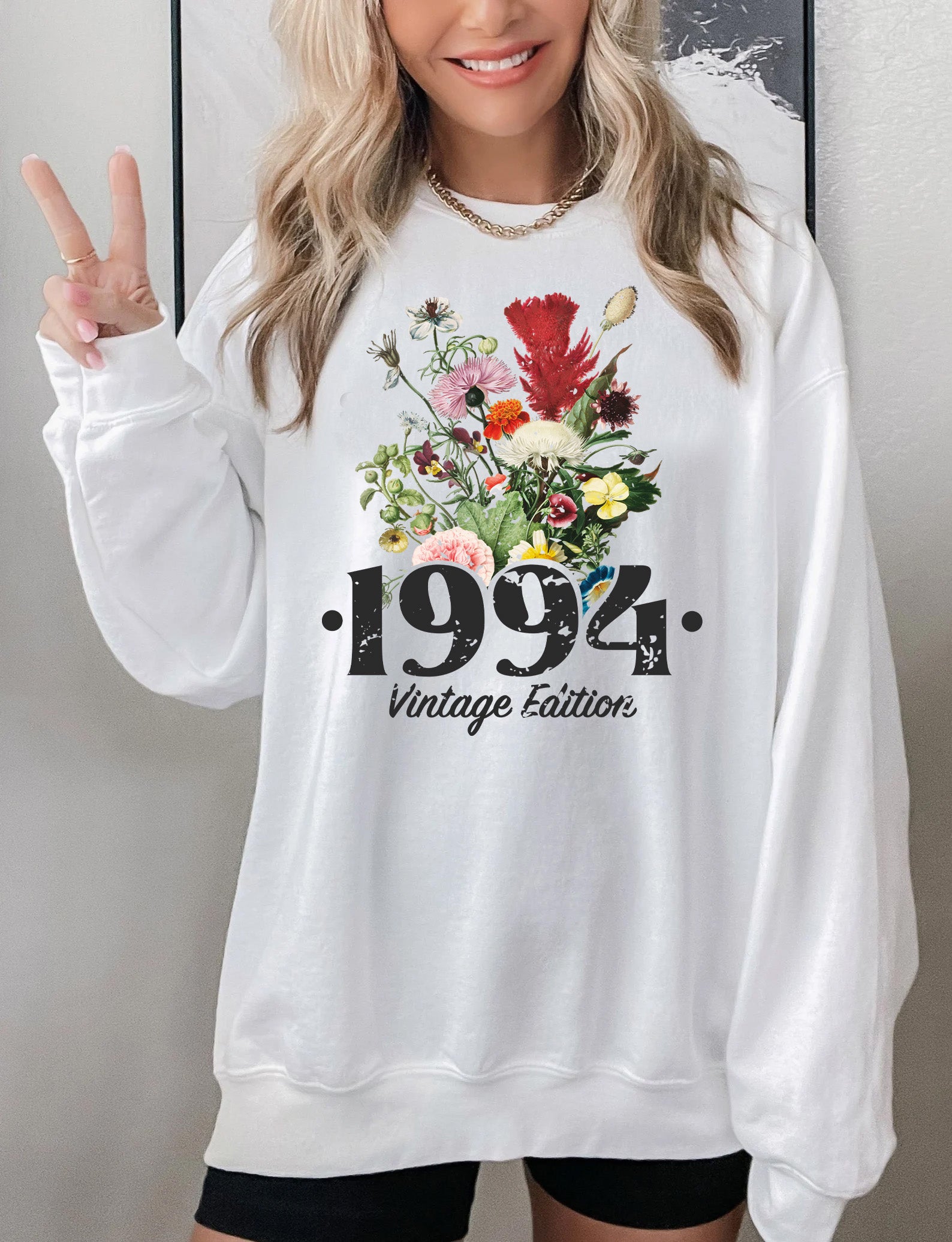 a woman wearing a white sweatshirt and black shorts